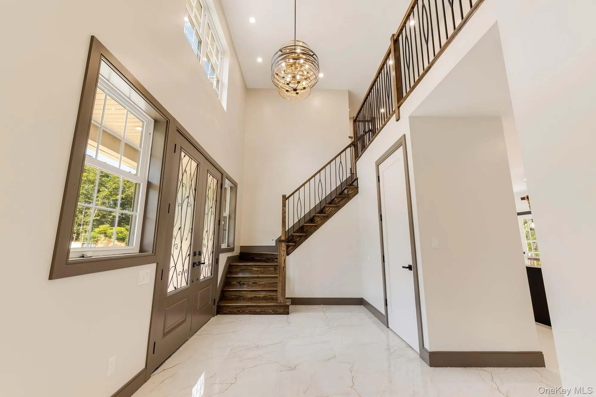 Foyer featuring an inviting chandelier, recessed lighting, marble finish floor, stairs. Foyer featuring an inviting chandelier, recessed lighting, marble finish floor, stairs.