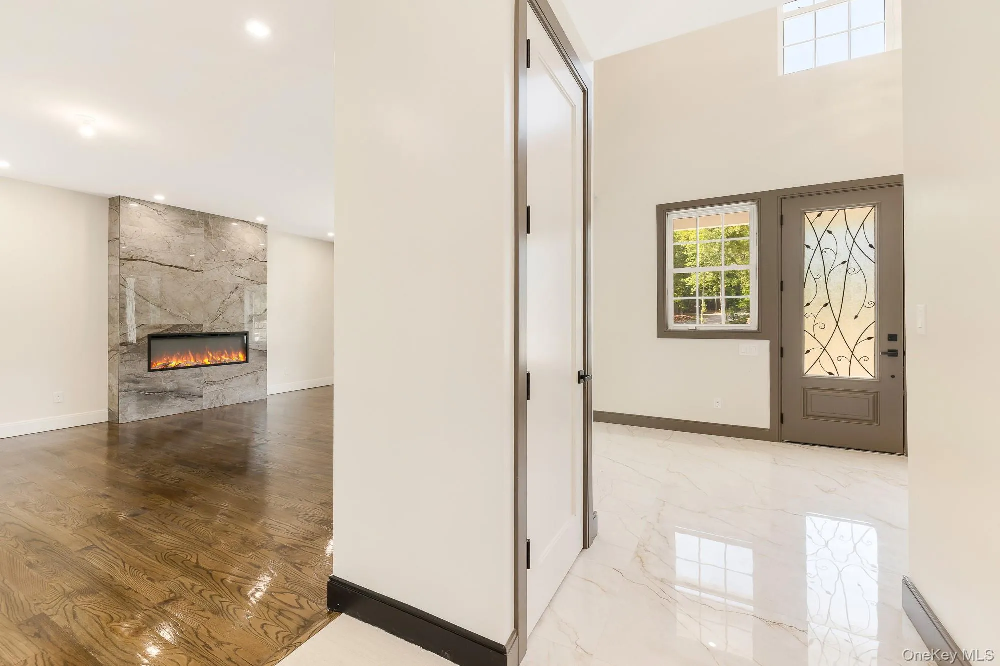 Foyer featuring recessed lighting, a high end fireplace, and marble finish floor. Foyer featuring recessed lighting, a high end fireplace, and marble finish floor.
