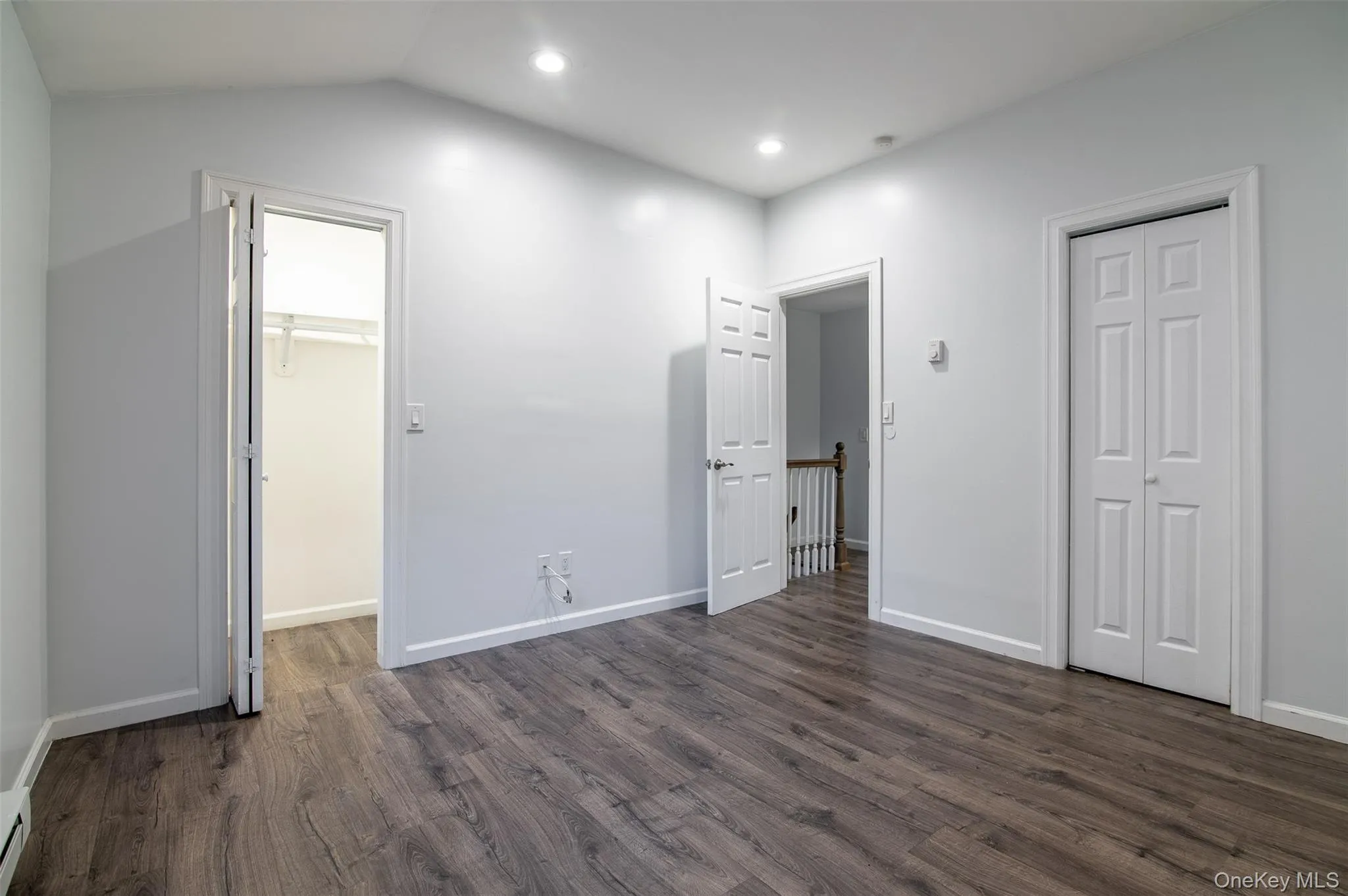Unfurnished bedroom with dark wood-type flooring, recessed lighting, and a baseboard radiator Unfurnished bedroom with dark wood-type flooring, recessed lighting, and a baseboard radiator