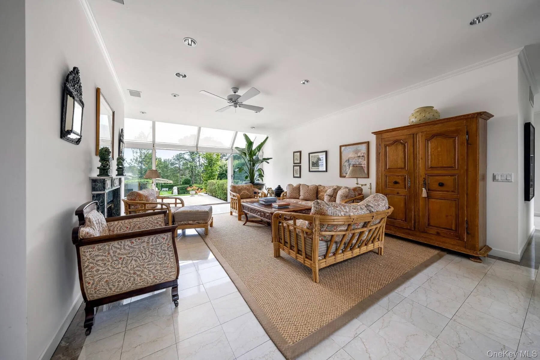 Living room with expansive windows, ceiling fan, light marble finish flooring, and ornamental molding Living room with expansive windows, ceiling fan, light marble finish flooring, and ornamental molding