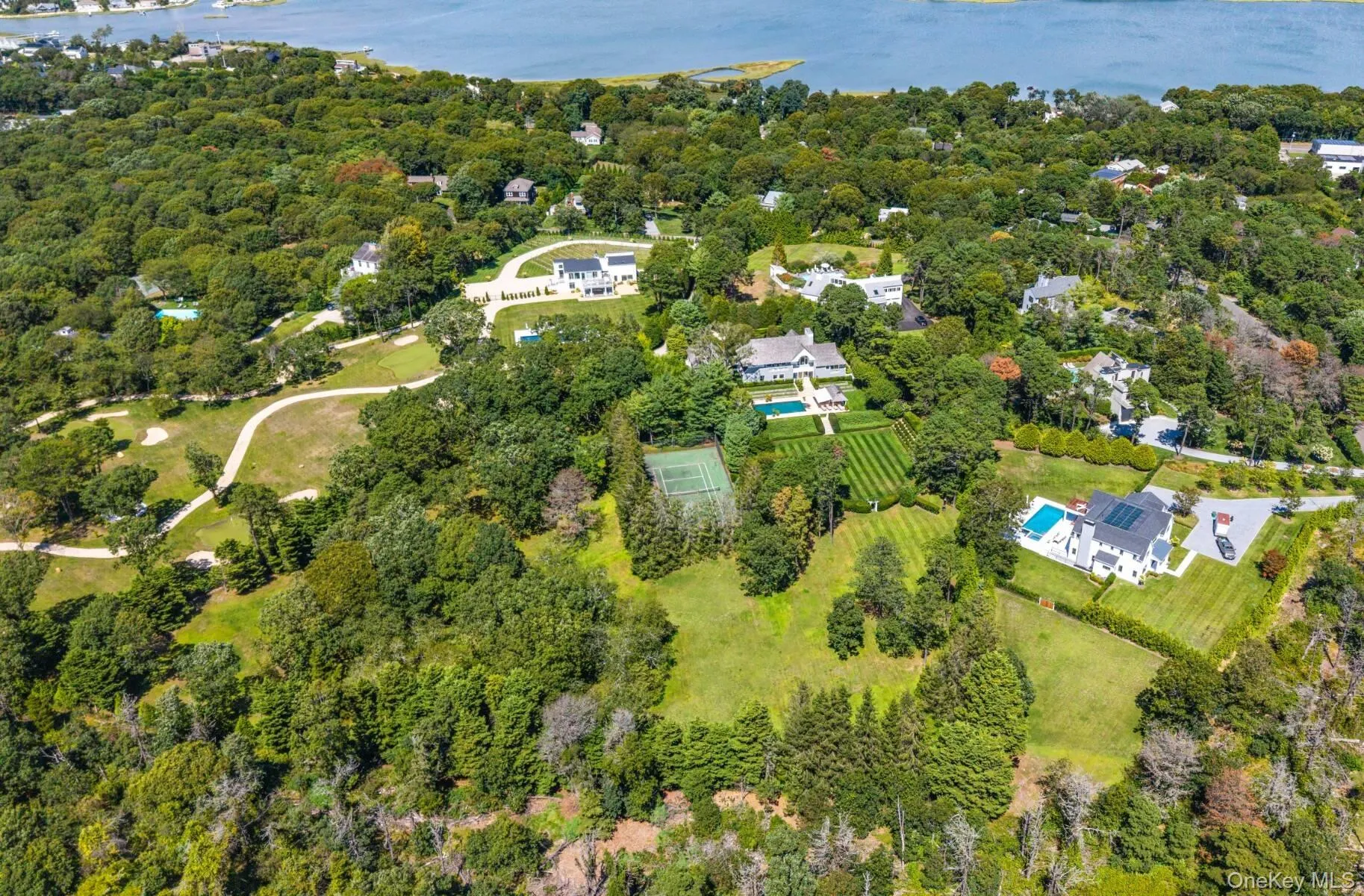 Aerial view of property's location featuring a large body of water and a heavily wooded area Aerial view of property's location featuring a large body of water and a heavily wooded area