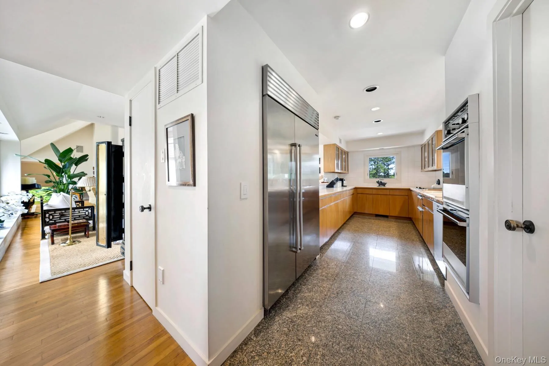 Kitchen with appliances with stainless steel finishes, granite floors, modern cabinets, brown cabinets, and recessed lighting Kitchen with appliances with stainless steel finishes, granite floors, modern cabinets, brown cabinets, and recessed lighting