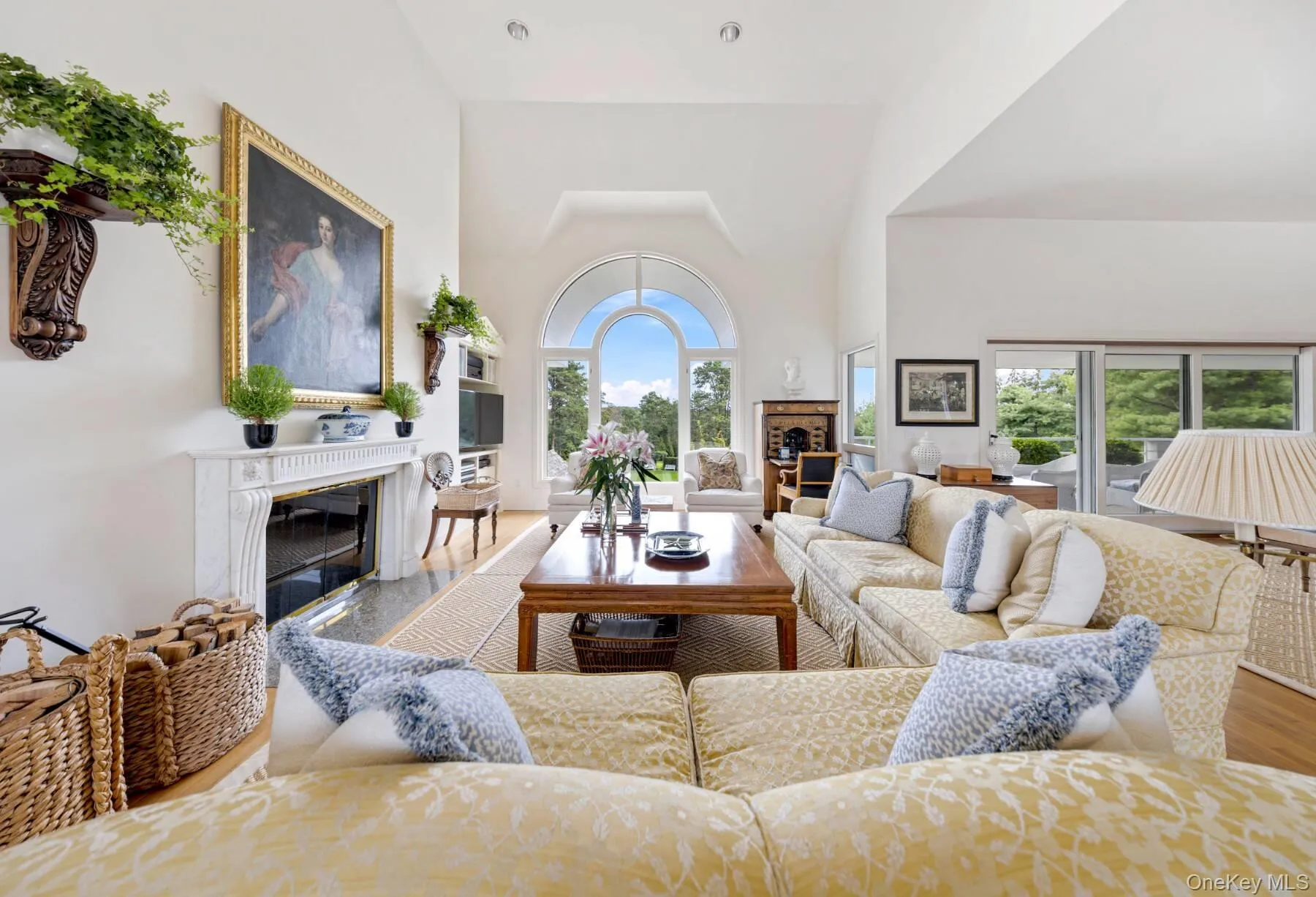 Living room with a high end fireplace, a high ceiling, and wood finished floors Living room with a high end fireplace, a high ceiling, and wood finished floors
