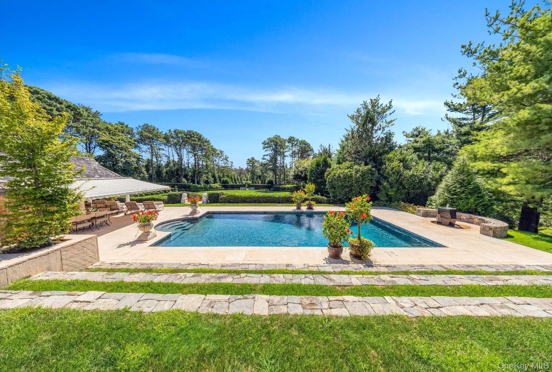 Swimming pool with a patio area and view of scattered trees Swimming pool with a patio area and view of scattered trees