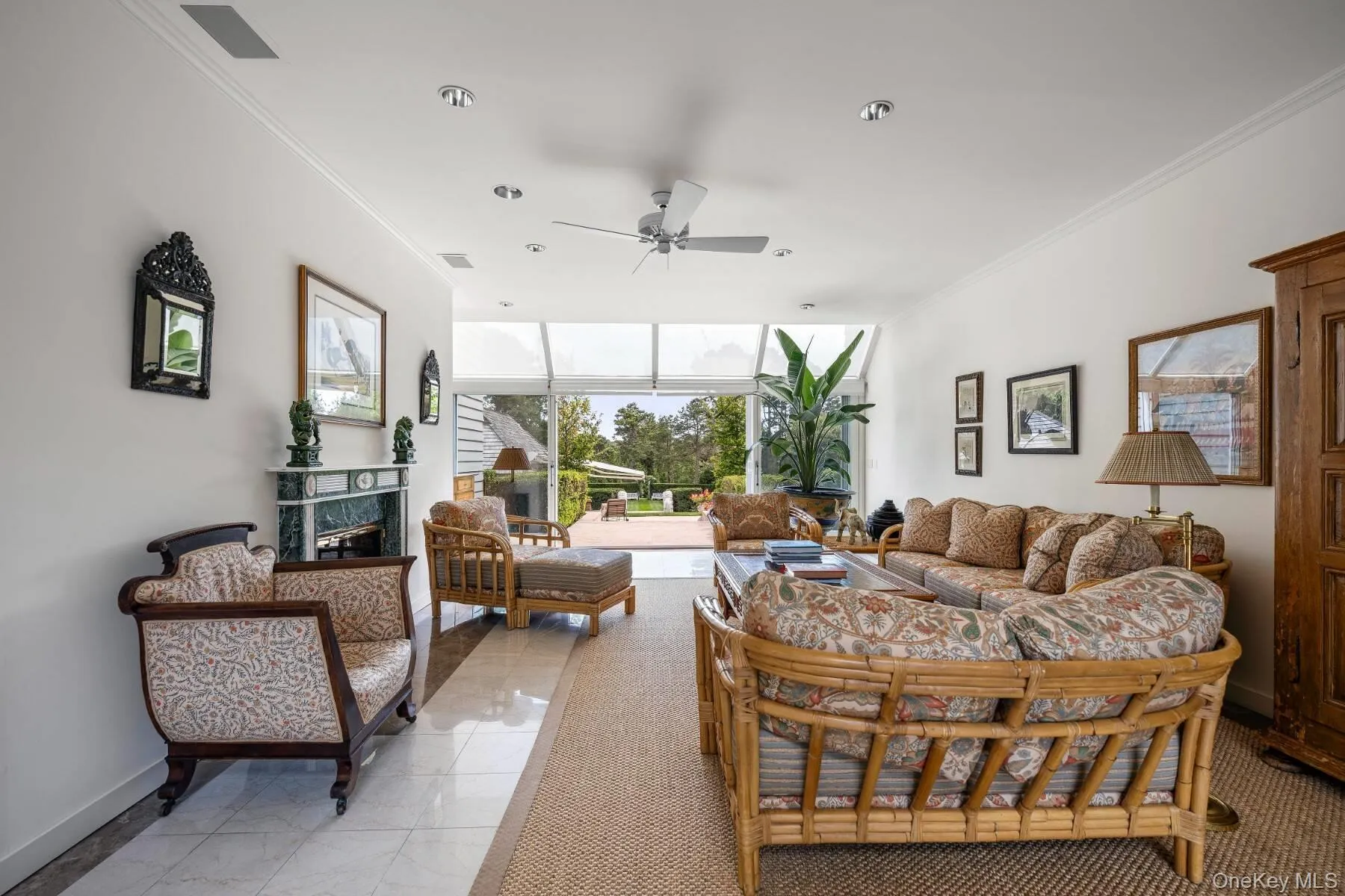 Living area featuring ornamental molding, expansive windows, ceiling fan, and light tile patterned flooring Living area featuring ornamental molding, expansive windows, ceiling fan, and light tile patterned flooring