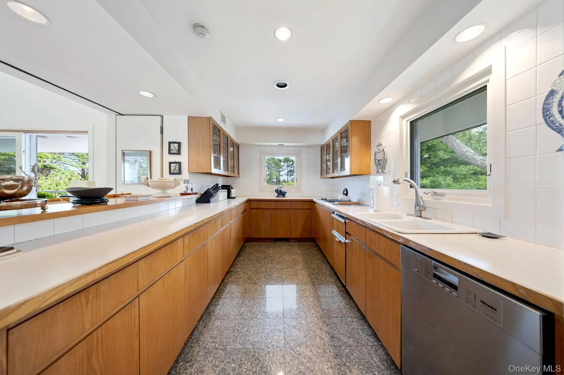 Kitchen featuring recessed lighting, granite floors, dishwasher, glass insert cabinets, and backsplash Kitchen featuring recessed lighting, granite floors, dishwasher, glass insert cabinets, and backsplash