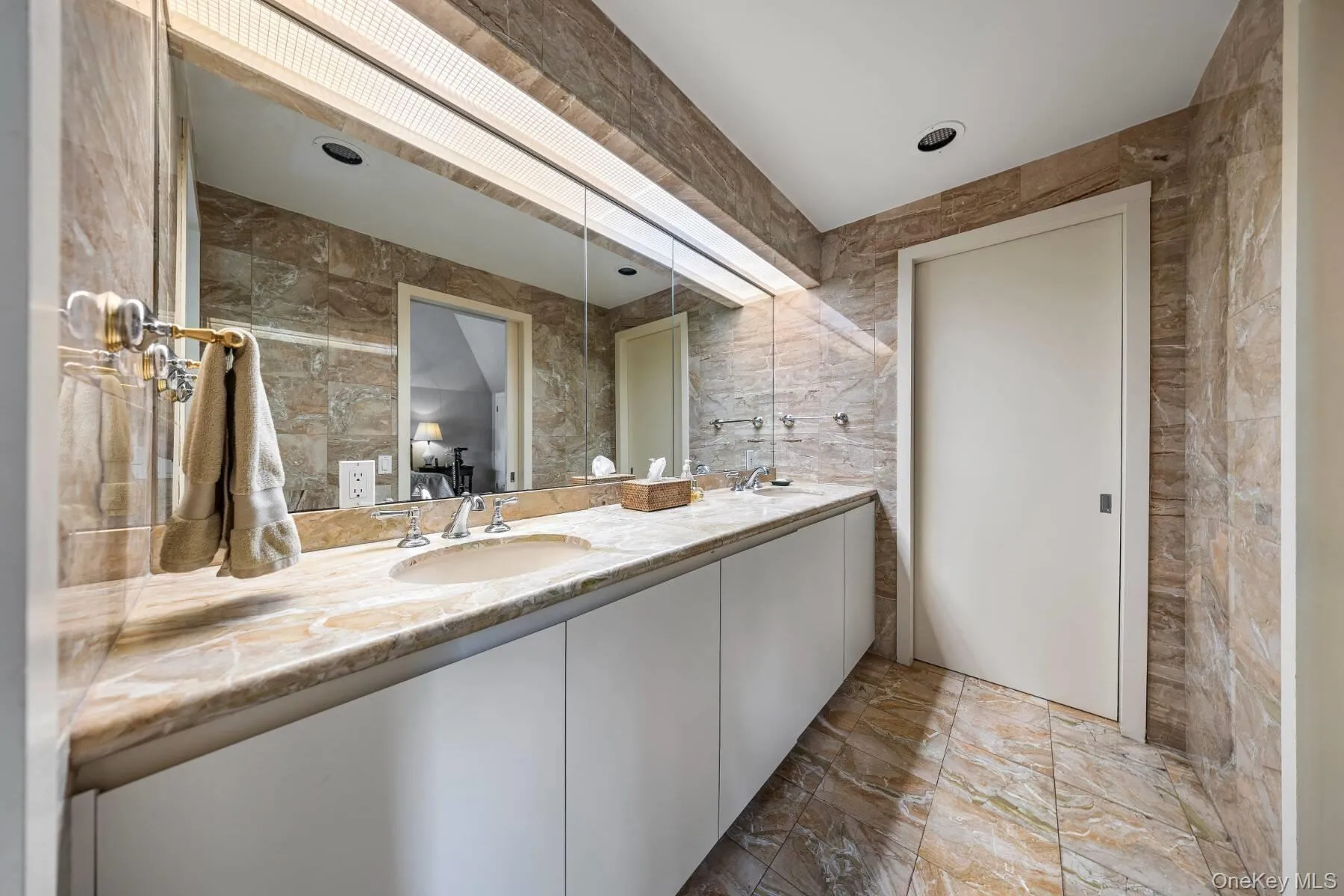 Full bath featuring double vanity and tile walls Full bath featuring double vanity and tile walls