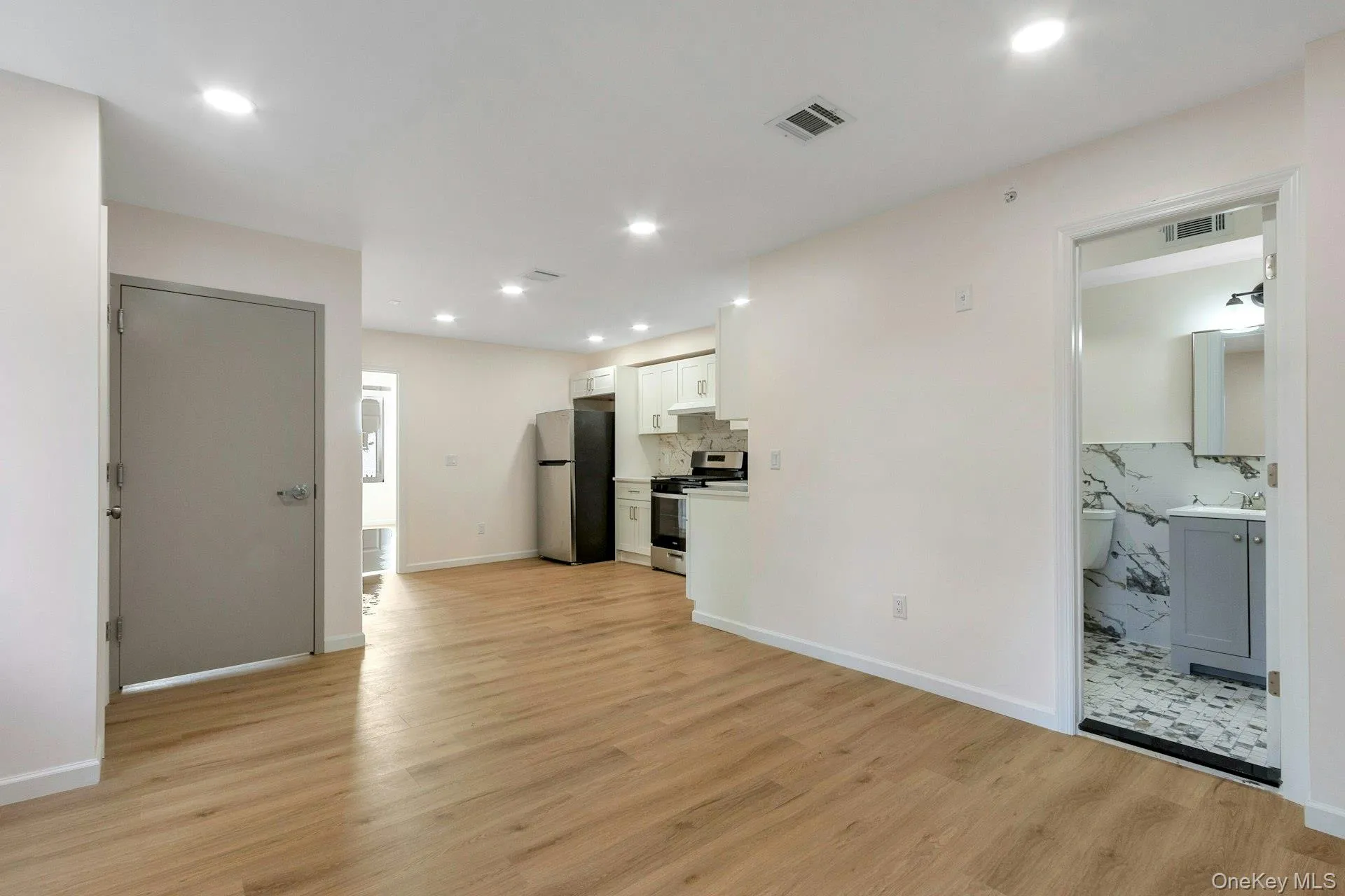 Unfurnished living room with light wood-type flooring and recessed lighting Unfurnished living room with light wood-type flooring and recessed lighting
