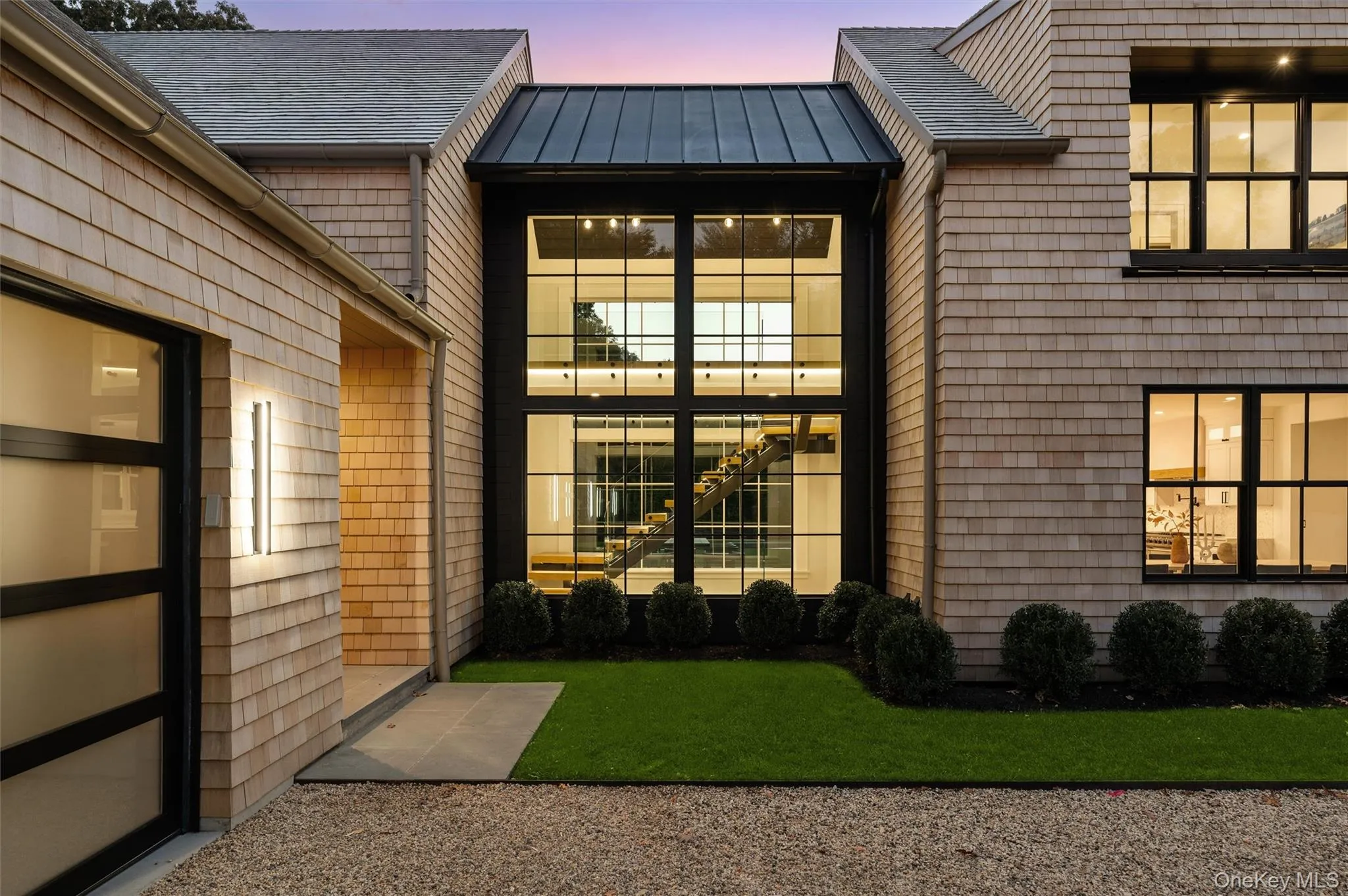 Exterior entry at dusk featuring a standing seam roof, a metal roof, and a yard Exterior entry at dusk featuring a standing seam roof, a metal roof, and a yard