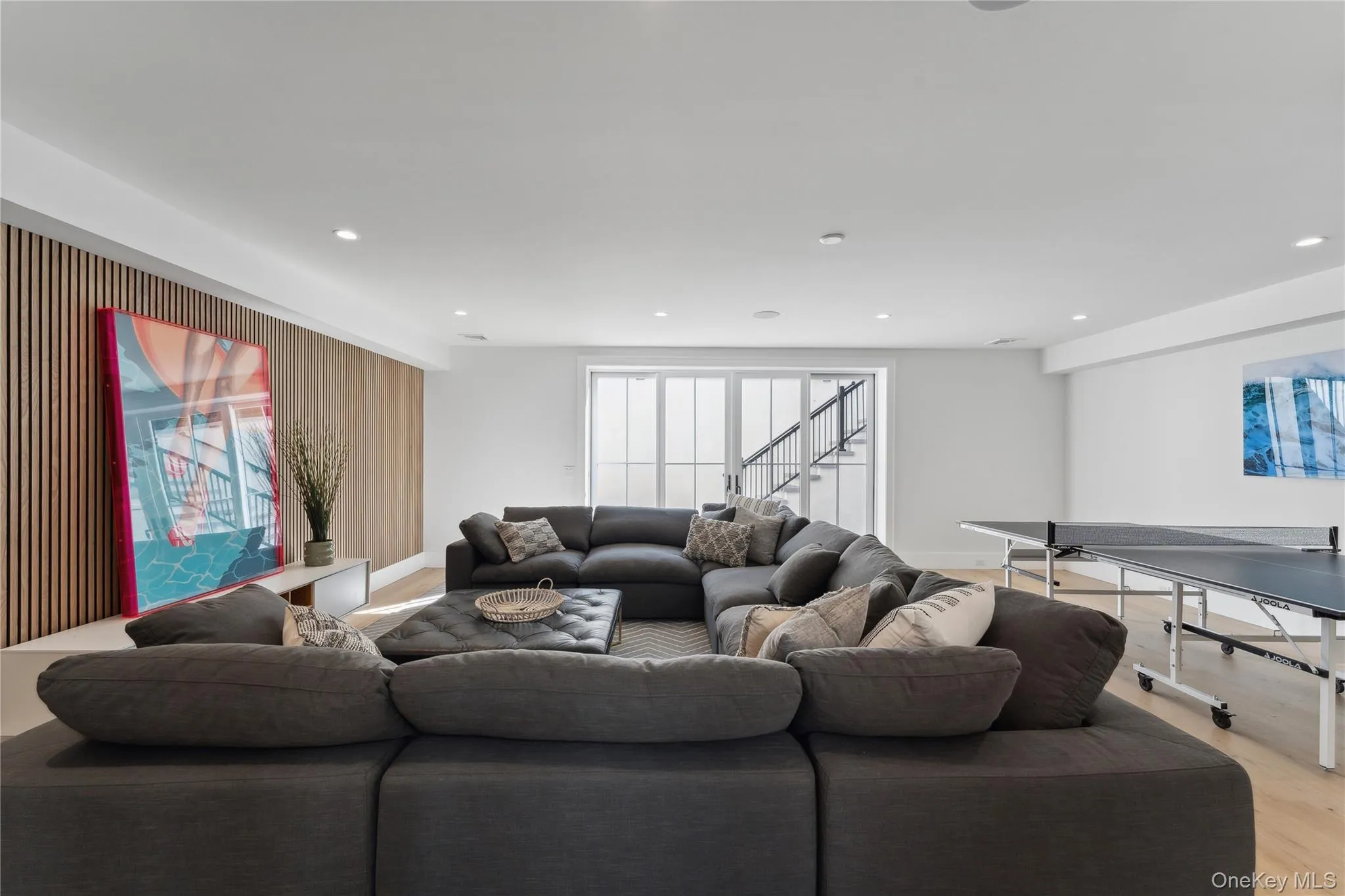 Living area featuring wood finished floors, recessed lighting, and stairway Living area featuring wood finished floors, recessed lighting, and stairway