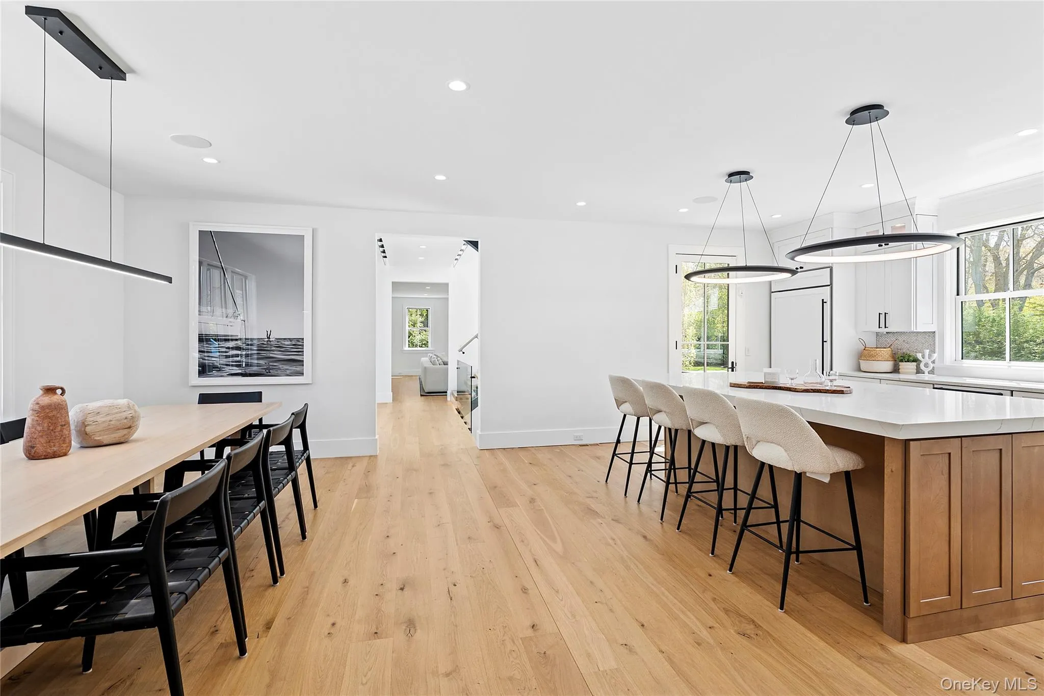 Kitchen featuring hanging light fixtures, brown cabinetry, a breakfast bar area, a large island, and light wood-type flooring Kitchen featuring hanging light fixtures, brown cabinetry, a breakfast bar area, a large island, and light wood-type flooring