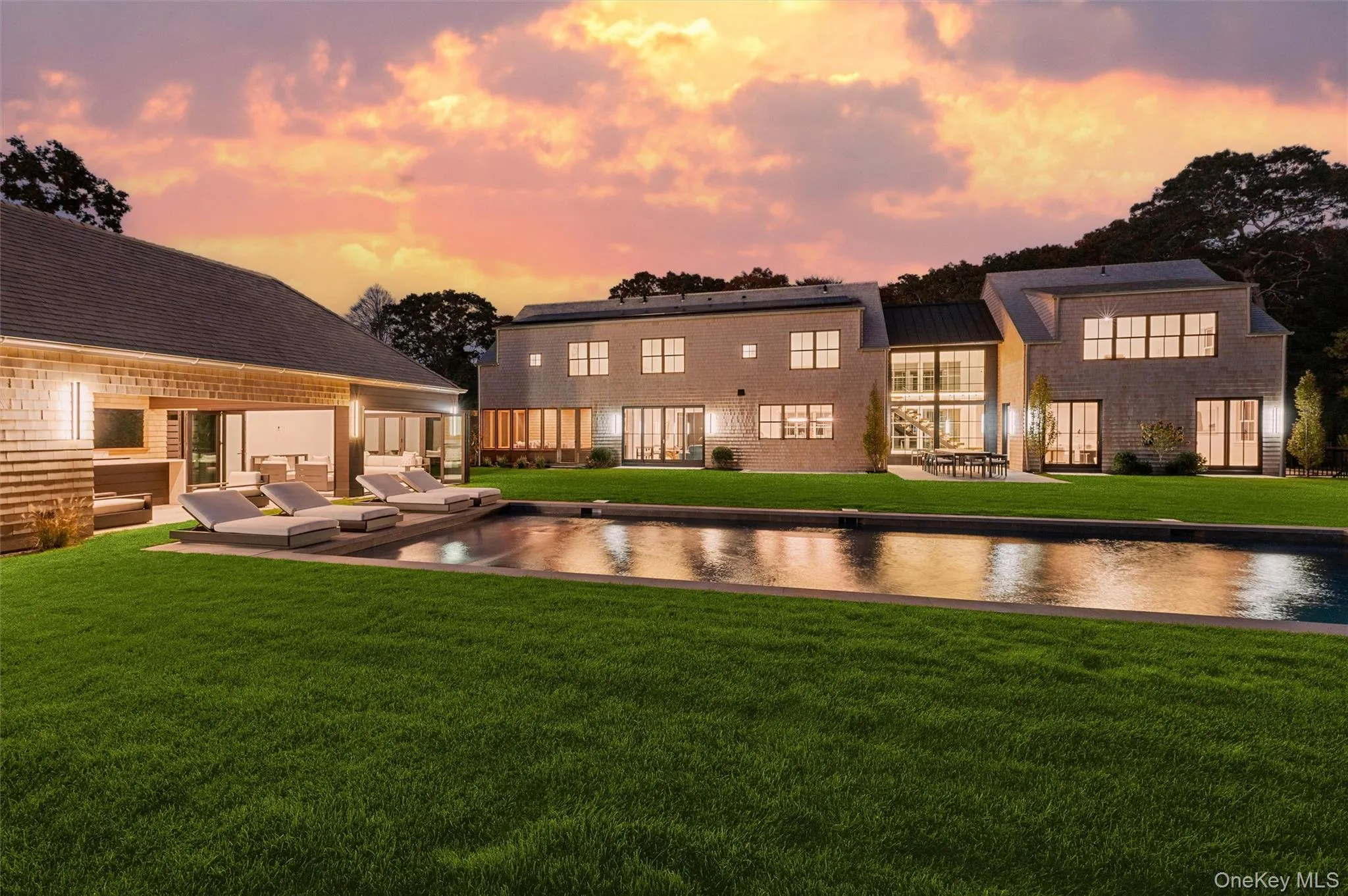 Back of property at dusk with a patio area and a yard Back of property at dusk with a patio area and a yard