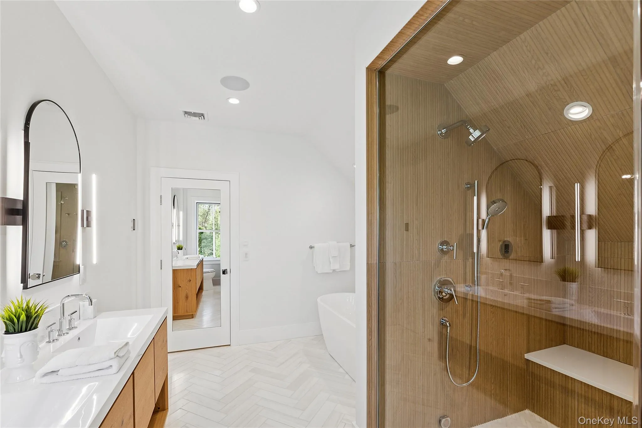 Full bathroom with a stall shower, a soaking tub, double vanity, recessed lighting, and lofted ceiling Full bathroom with a stall shower, a soaking tub, double vanity, recessed lighting, and lofted ceiling