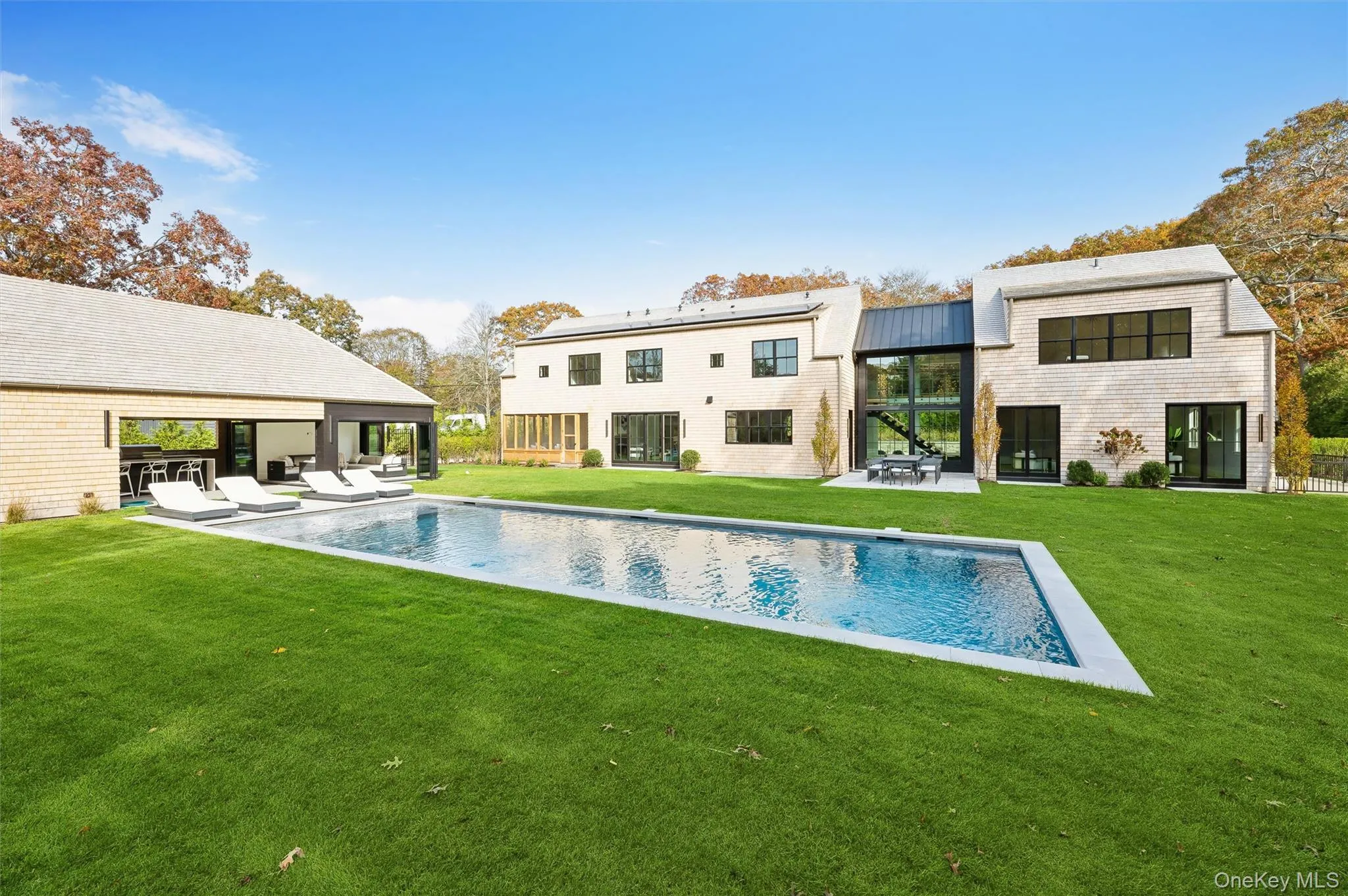Back of house with a patio, a yard, an outdoor pool, and a metal roof Back of house with a patio, a yard, an outdoor pool, and a metal roof