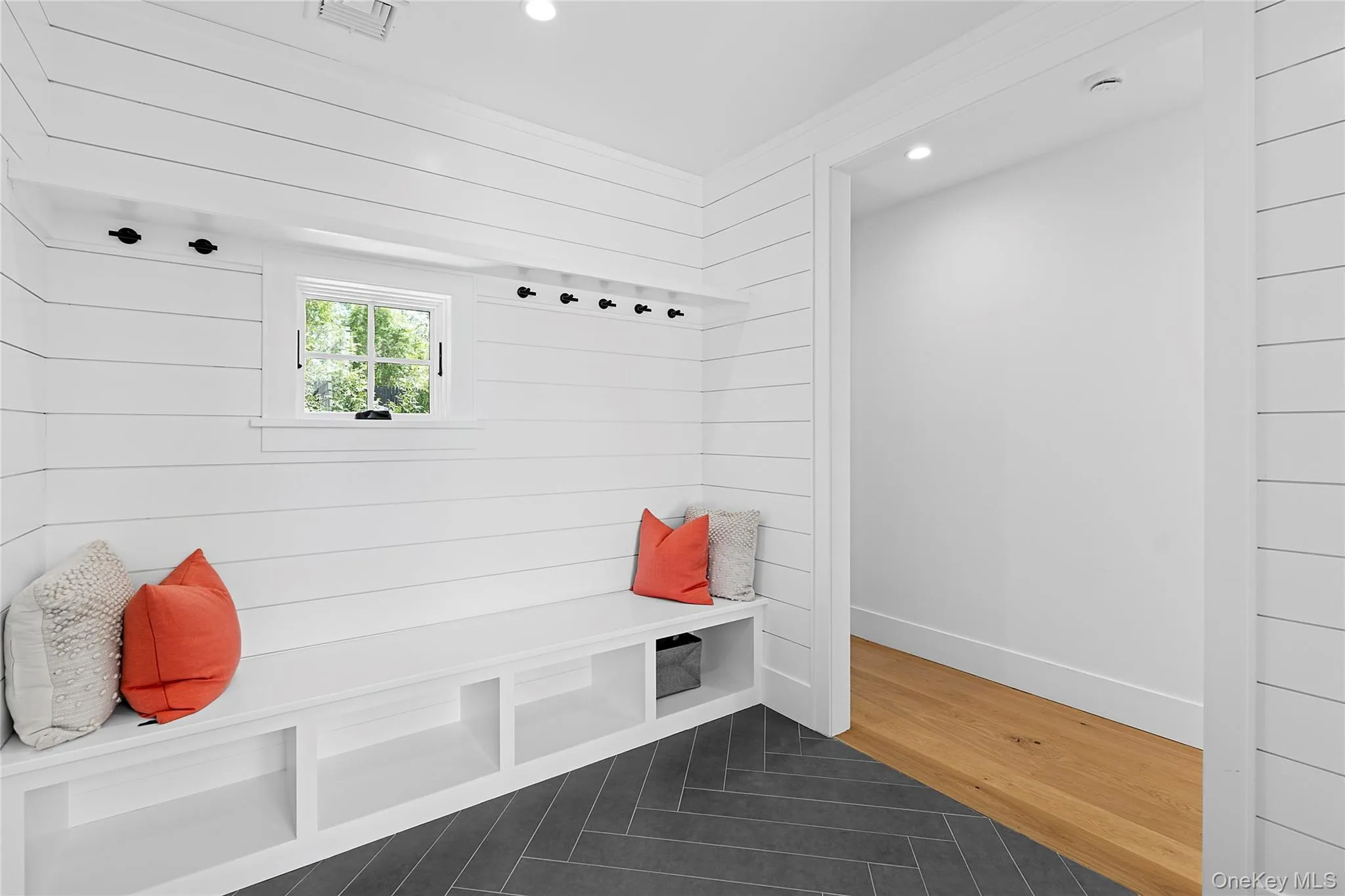 Mudroom with recessed lighting, dark tile patterned flooring, and wood walls Mudroom with recessed lighting, dark tile patterned flooring, and wood walls