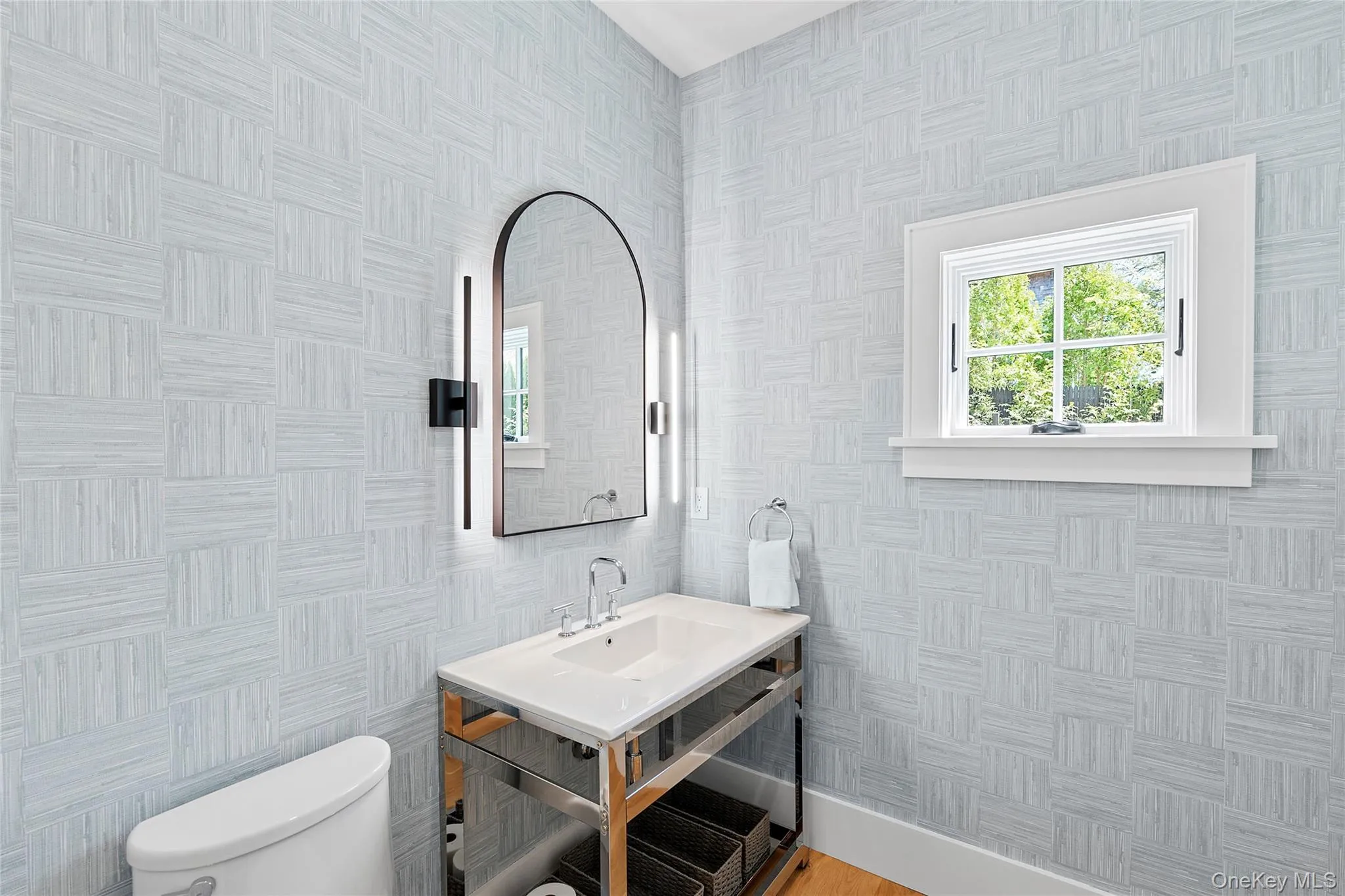 Half bathroom with toilet and wallpapered walls Half bathroom with toilet and wallpapered walls