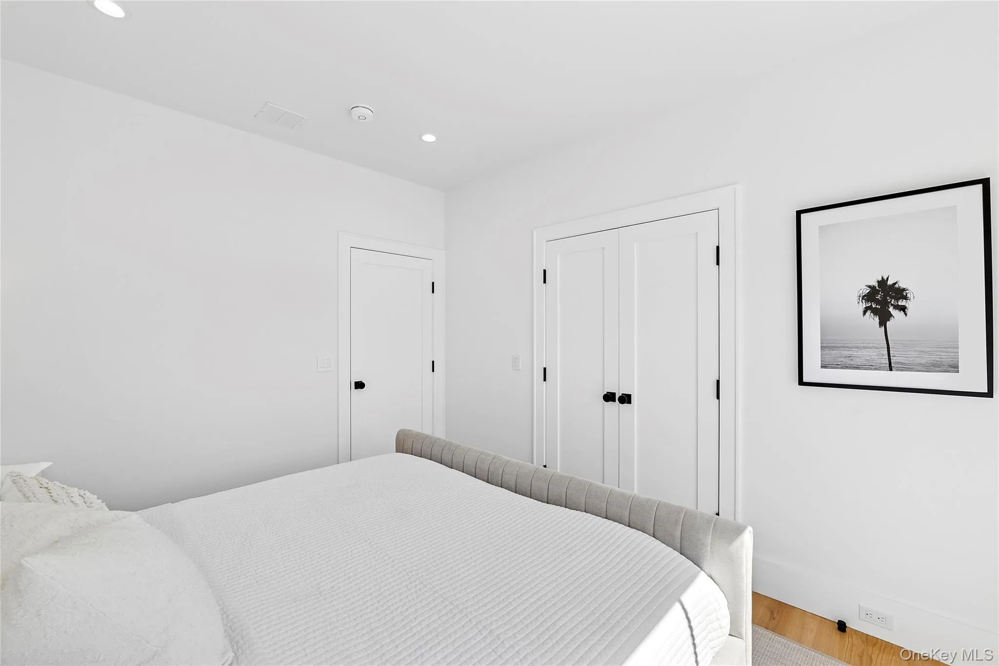 Bedroom with wood finished floors, recessed lighting, and a closet Bedroom with wood finished floors, recessed lighting, and a closet
