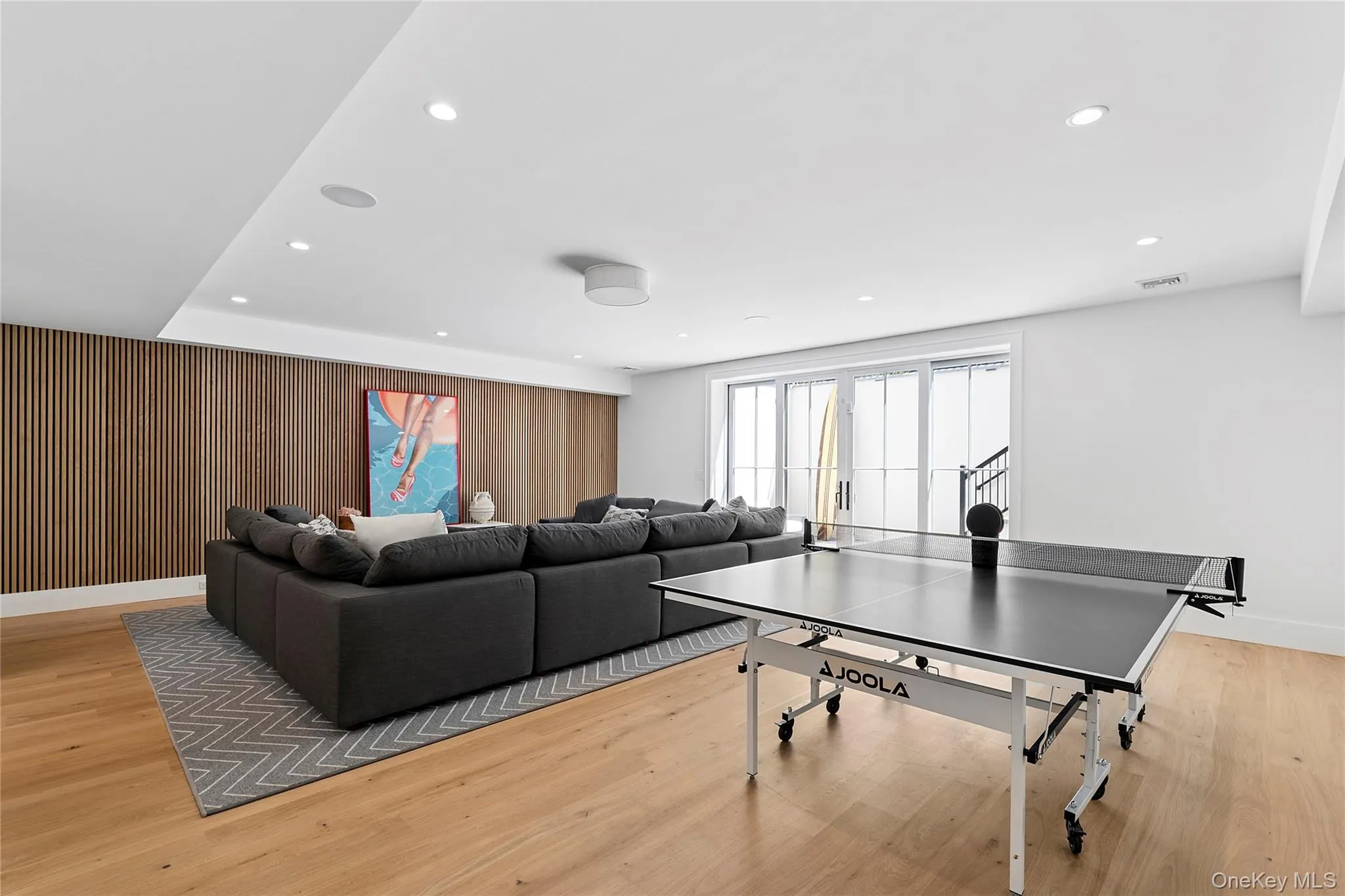 Rec room with wooden walls, recessed lighting, and light wood-style flooring Rec room with wooden walls, recessed lighting, and light wood-style flooring