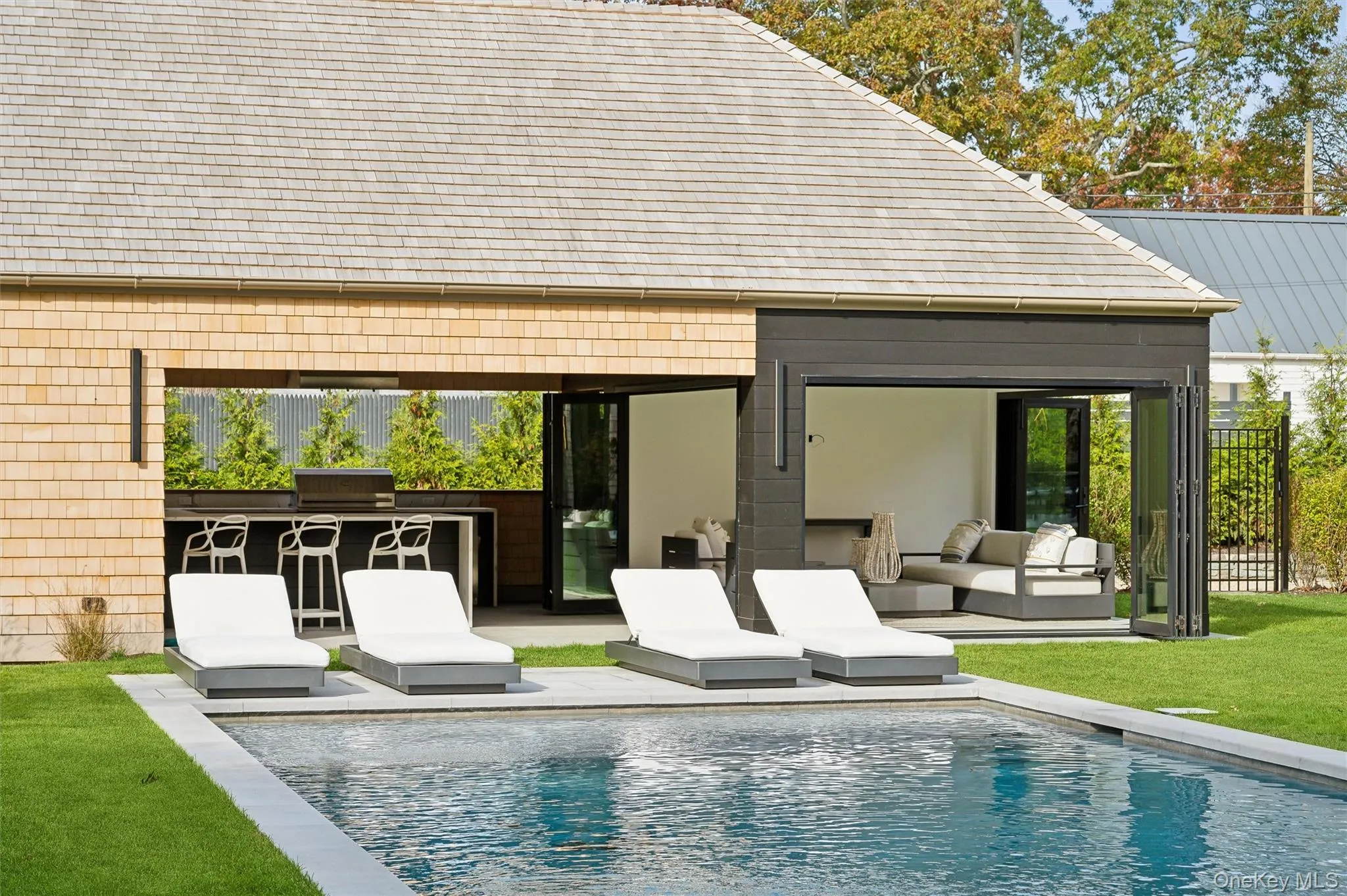 Rear view of house with an outdoor living space, a patio, an outdoor pool, a storage structure, and an outdoor structure Rear view of house with an outdoor living space, a patio, an outdoor pool, a storage structure, and an outdoor structure