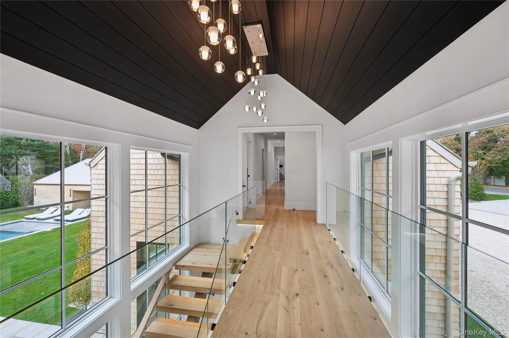 Hallway with light wood finished floors, lofted ceiling, and wooden ceiling Hallway with light wood finished floors, lofted ceiling, and wooden ceiling