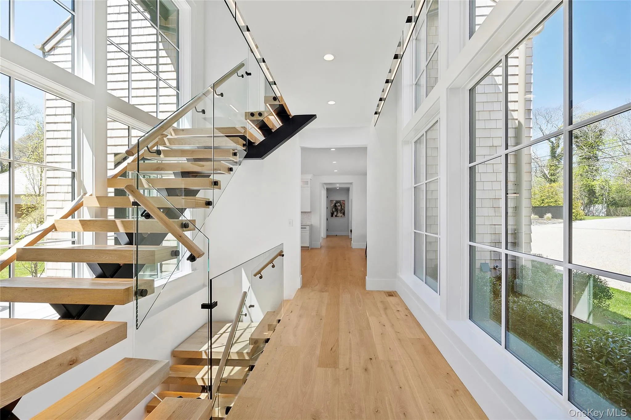 Stairway featuring plenty of natural light, wood finished floors, recessed lighting, and a towering ceiling Stairway featuring plenty of natural light, wood finished floors, recessed lighting, and a towering ceiling