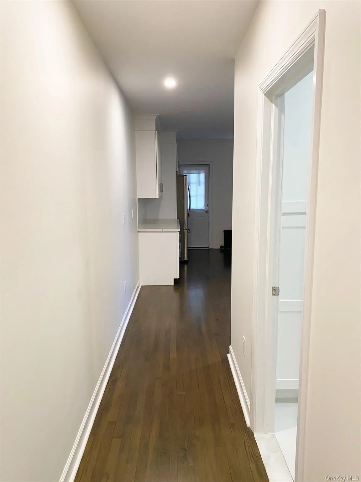Hallway featuring dark wood-style floors and baseboards Hallway featuring dark wood-style floors and baseboards
