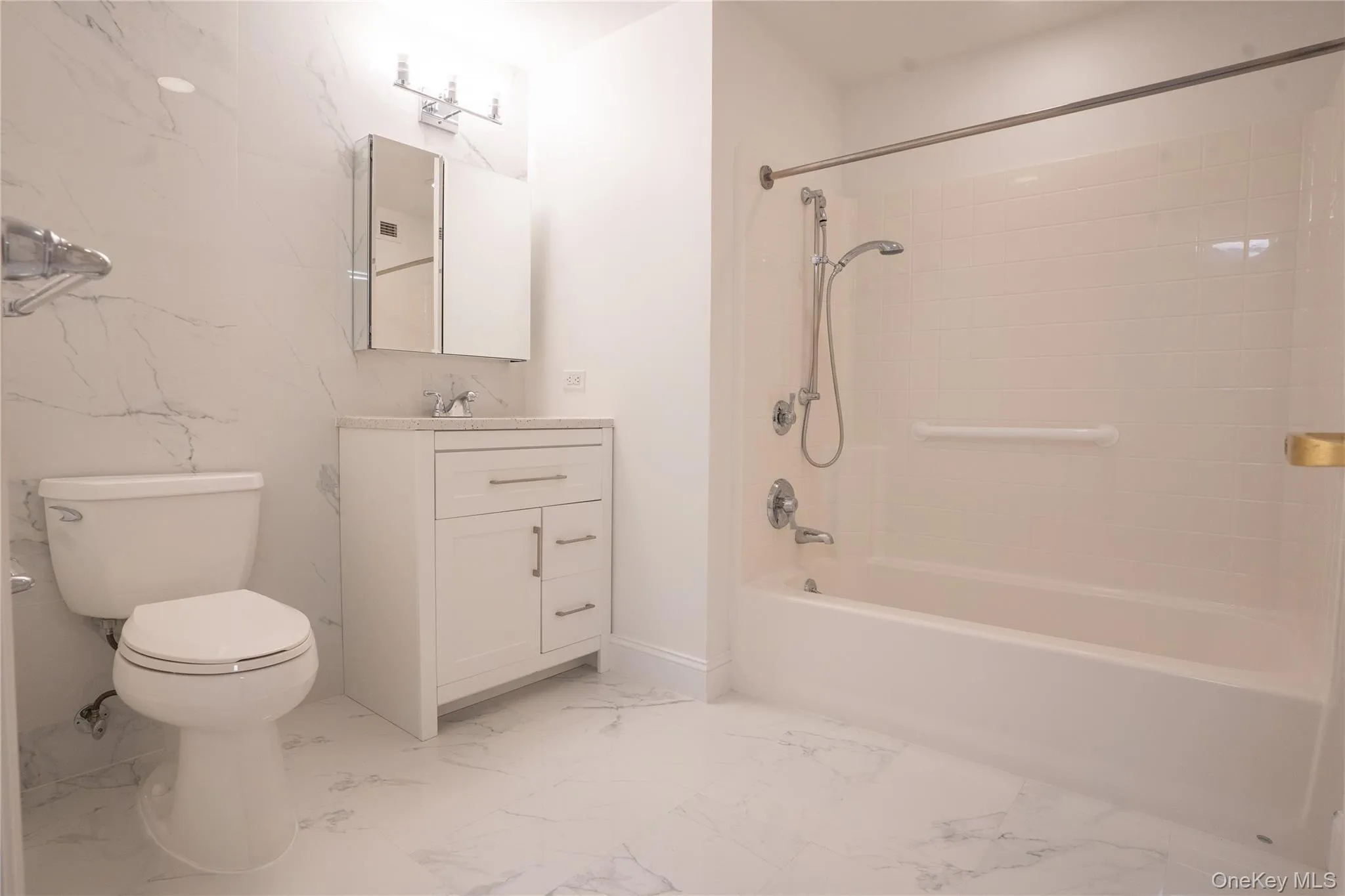 Main Full Bathroom featuring shower / bath combination, vanity, and light marble finish flooring with laundry room. Located near front door. Main Full Bathroom featuring shower / bath combination, vanity, and light marble finish flooring with laundry room. Located near front door.
