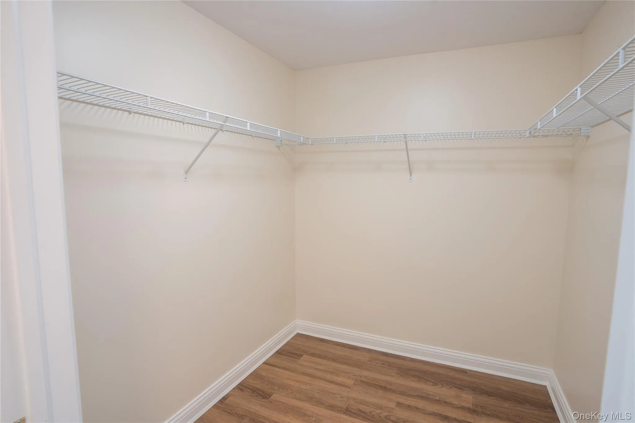 Walk in closet featuring wood finished floors Walk in closet featuring wood finished floors