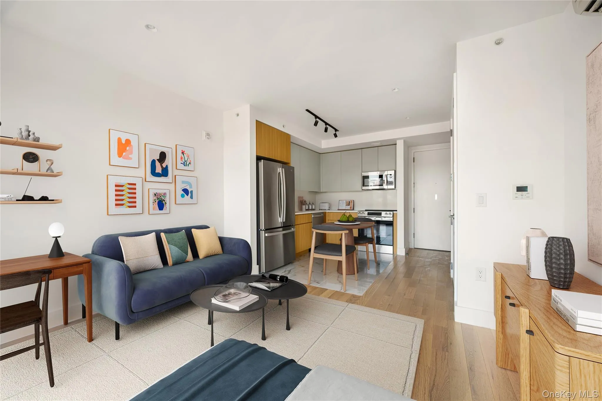 Living area featuring rail lighting and light wood-style flooring Living area featuring rail lighting and light wood-style flooring