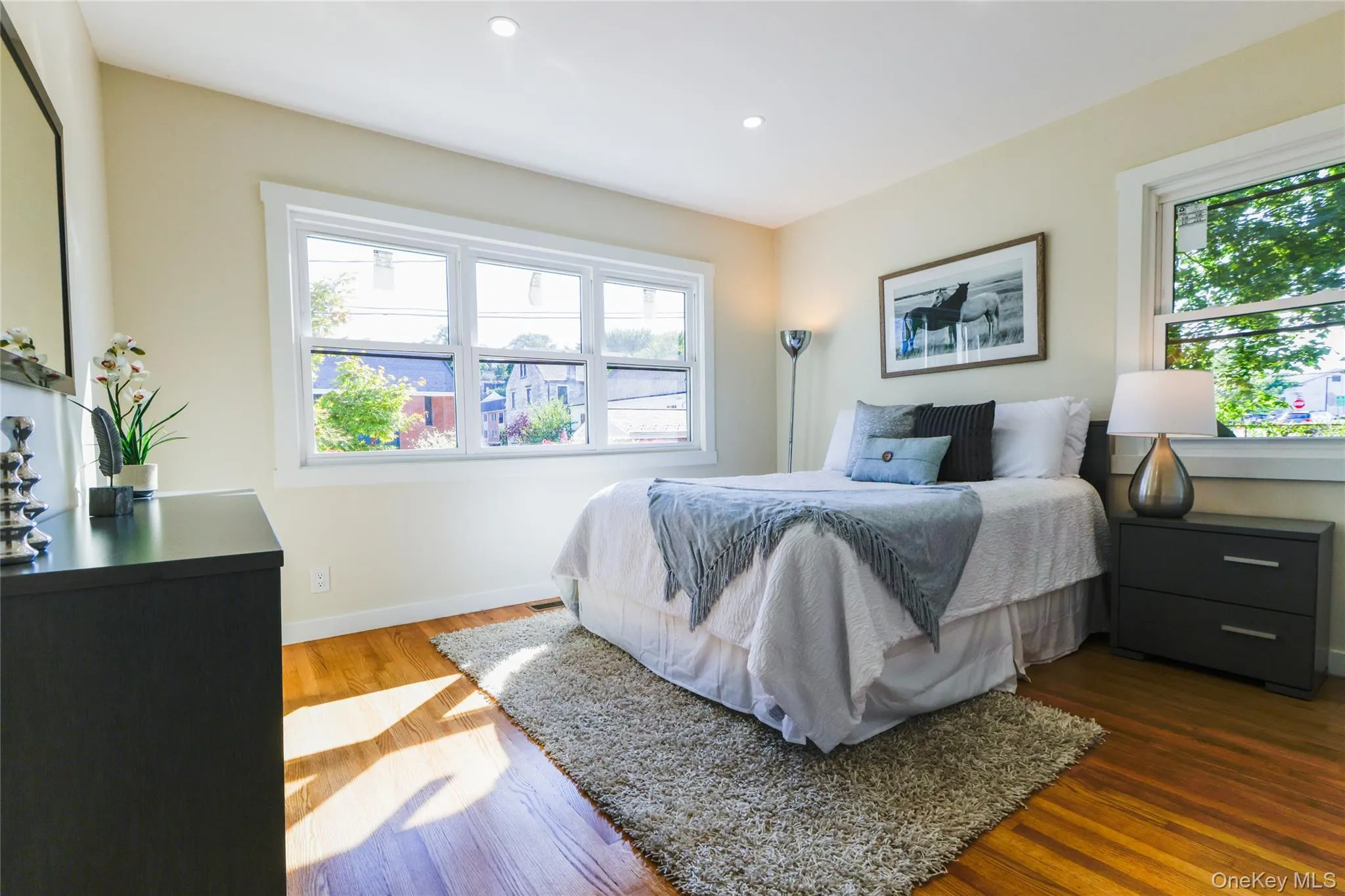 Bedroom featuring multiple windows, wood finished floors, and recessed lighting Bedroom featuring multiple windows, wood finished floors, and recessed lighting