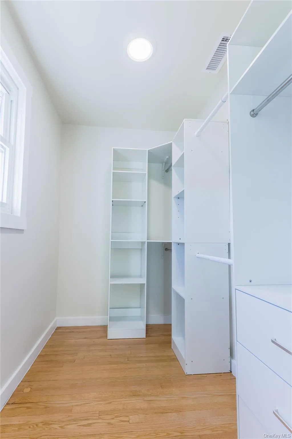 Walk in closet featuring light wood finished floors Walk in closet featuring light wood finished floors