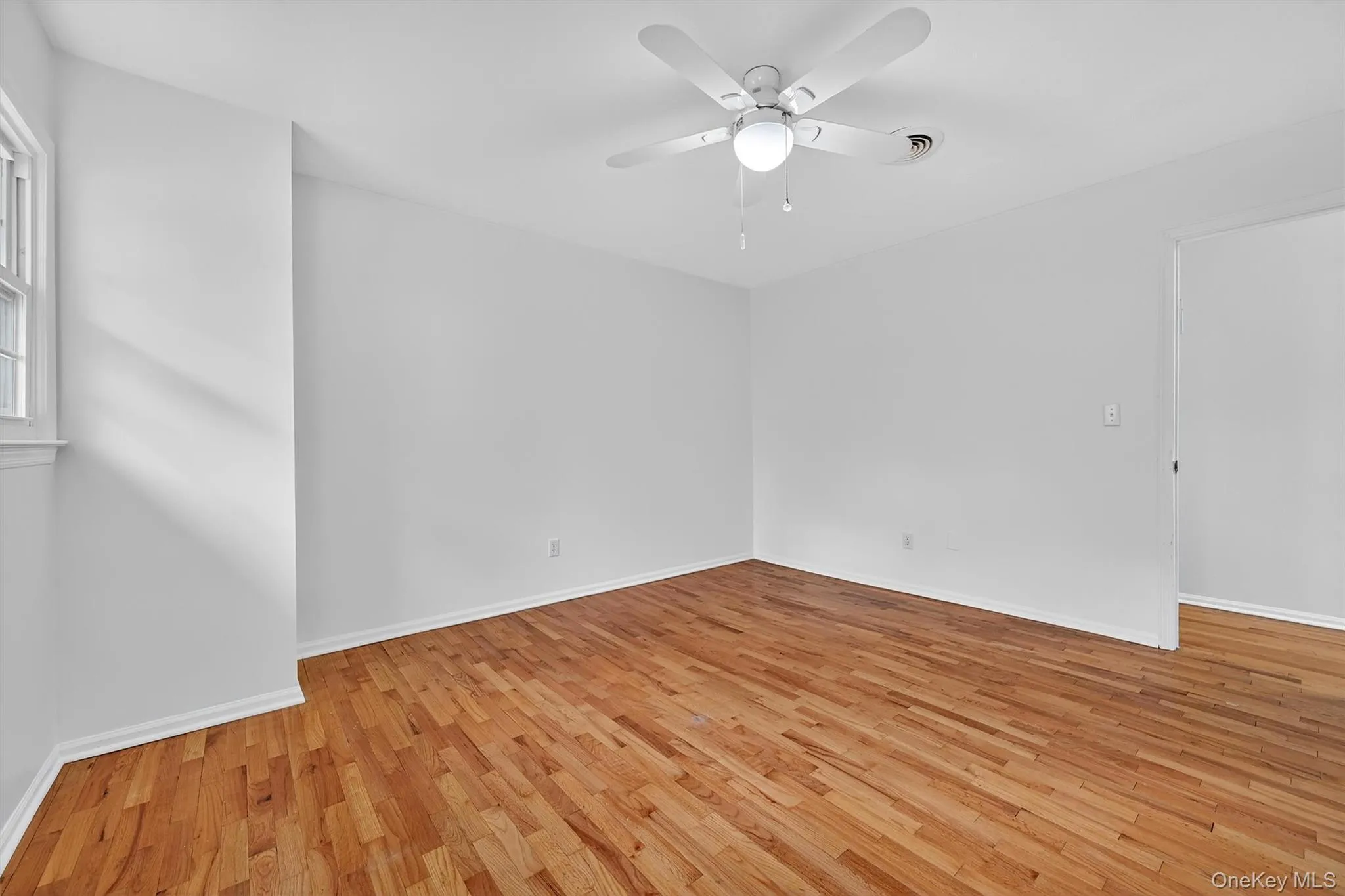 Unfurnished room with light wood-type flooring and a ceiling fan Unfurnished room with light wood-type flooring and a ceiling fan