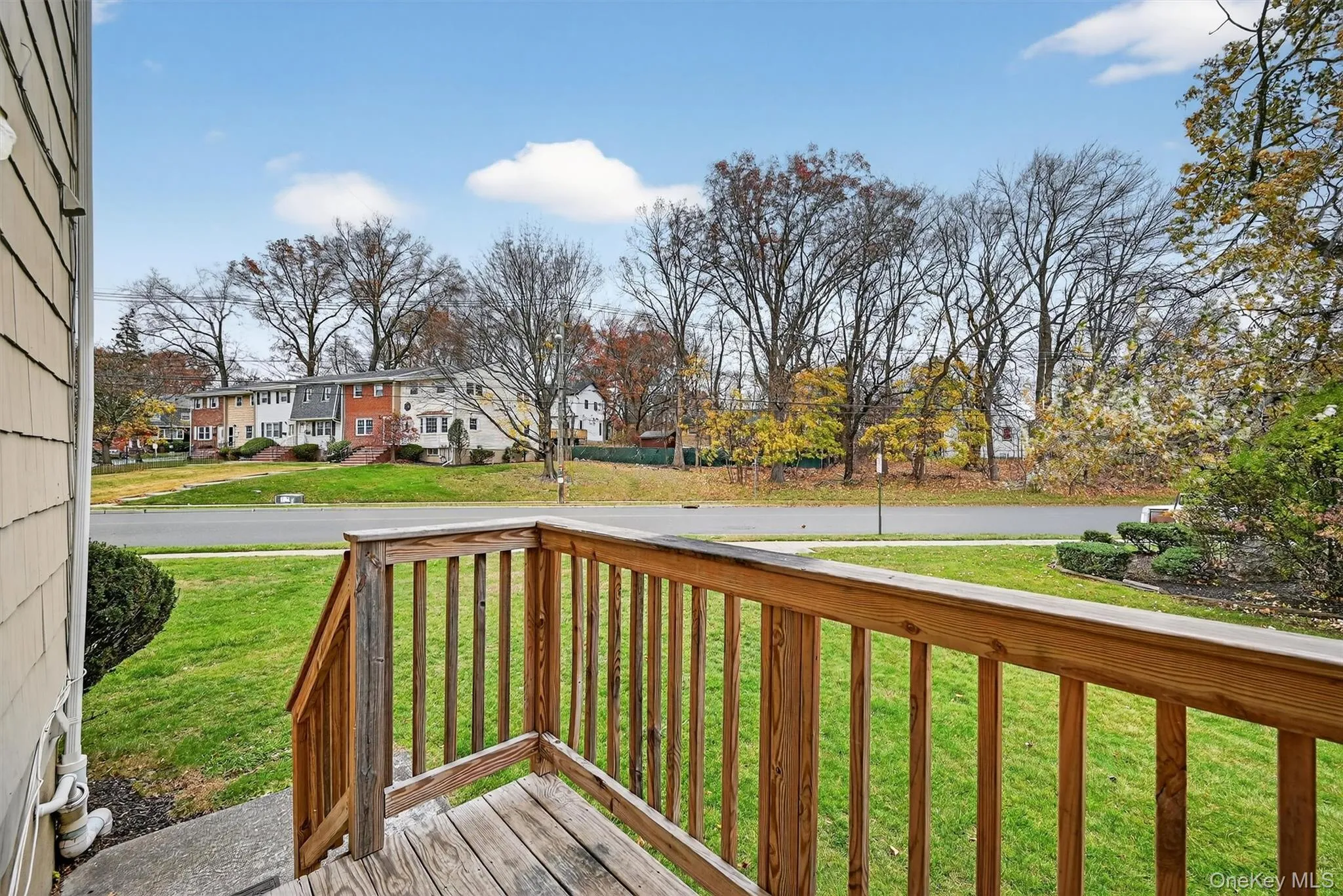 Wooden terrace with a yard and a residential view Wooden terrace with a yard and a residential view
