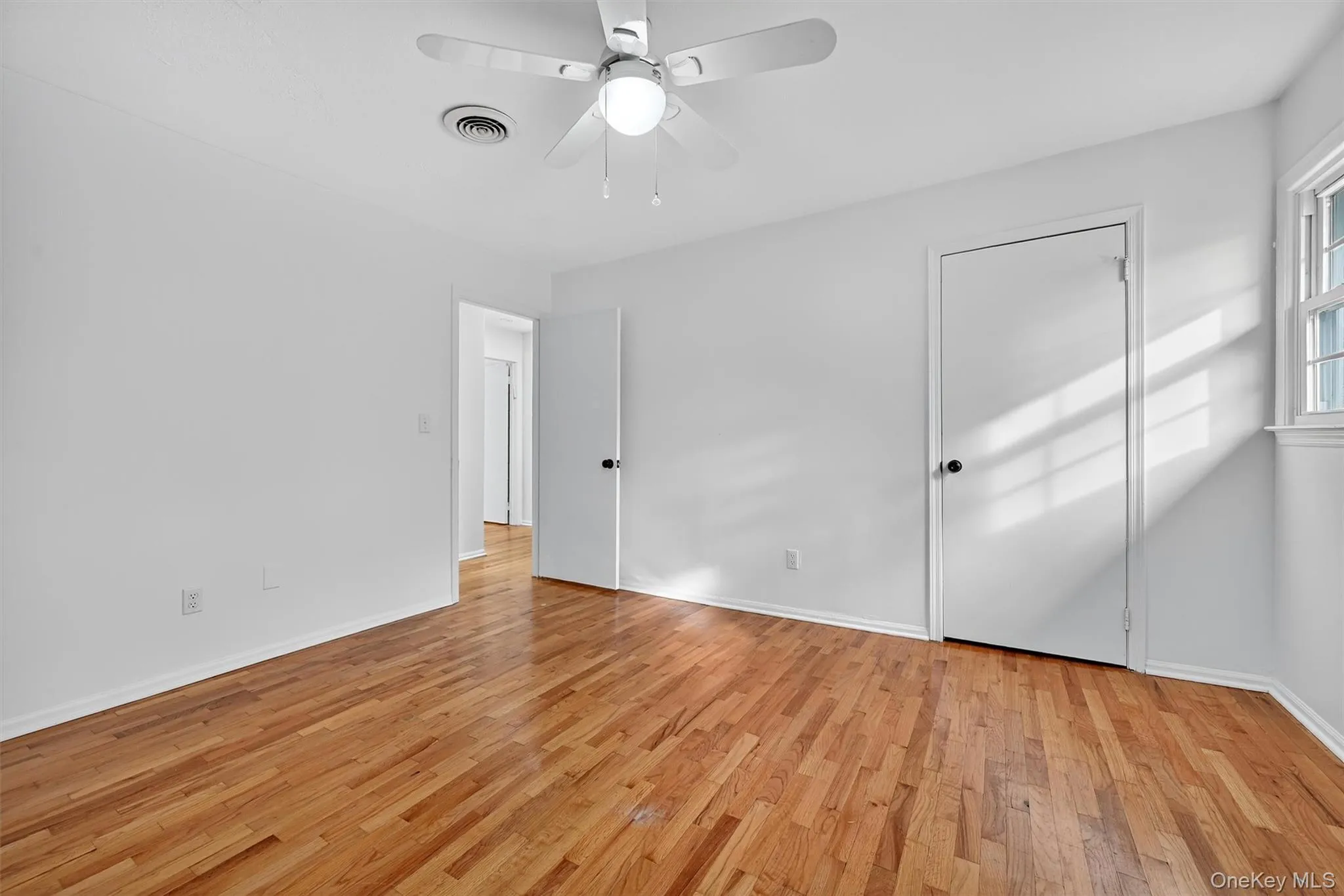 Unfurnished bedroom featuring light wood-style flooring and ceiling fan Unfurnished bedroom featuring light wood-style flooring and ceiling fan