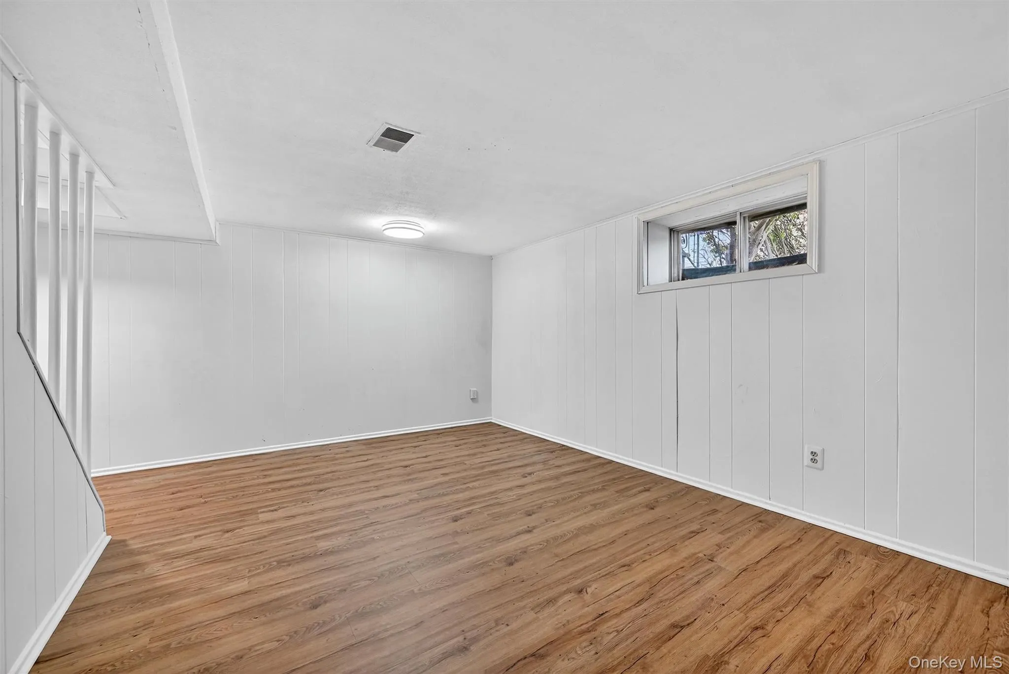 Below grade area featuring wood finished floors and wooden walls Below grade area featuring wood finished floors and wooden walls