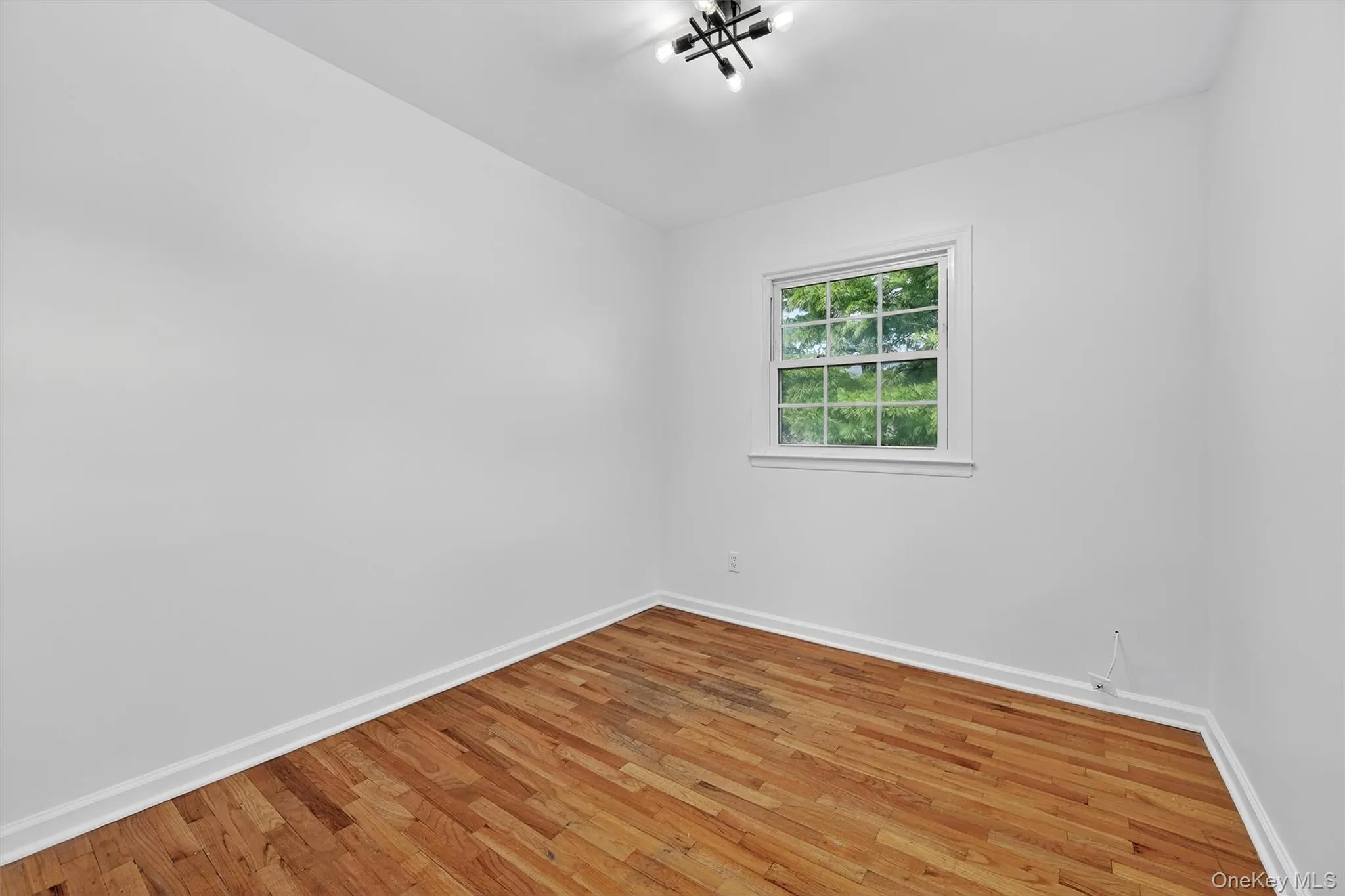 Spare room featuring light wood finished floors and baseboards Spare room featuring light wood finished floors and baseboards