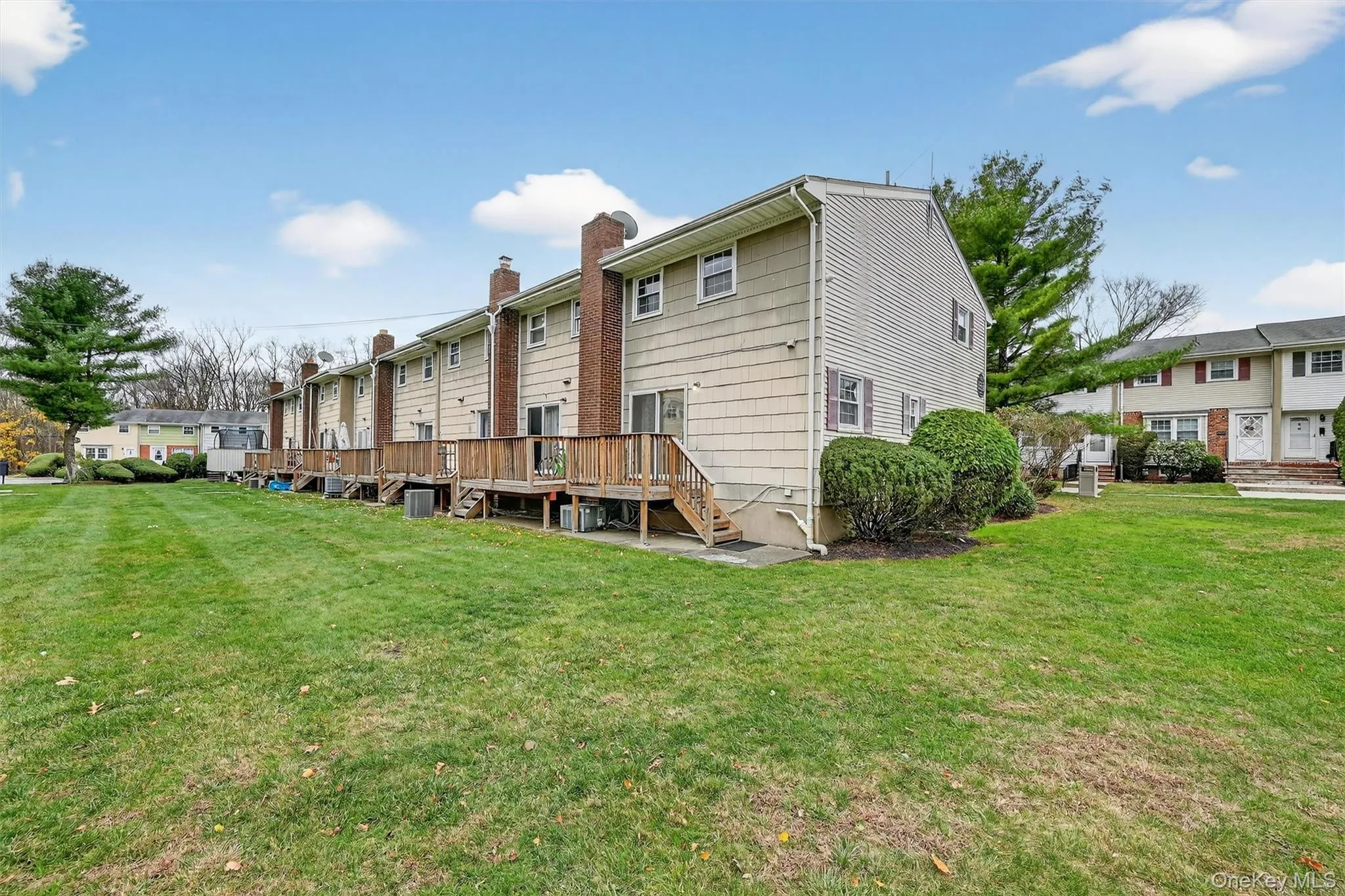 Back of house with a lawn, a residential view, and a wooden deck Back of house with a lawn, a residential view, and a wooden deck