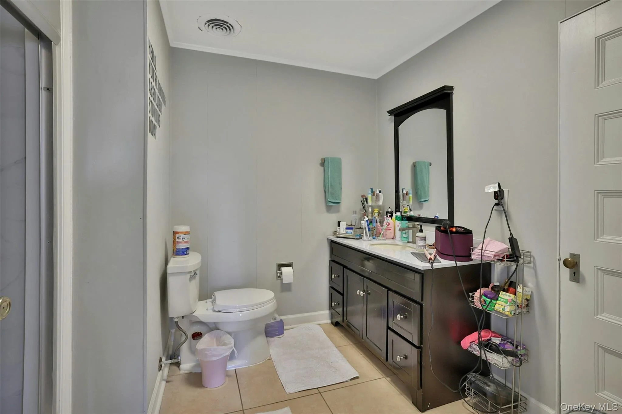 Full bath with light tile patterned floors, vanity, and ornamental molding Full bath with light tile patterned floors, vanity, and ornamental molding