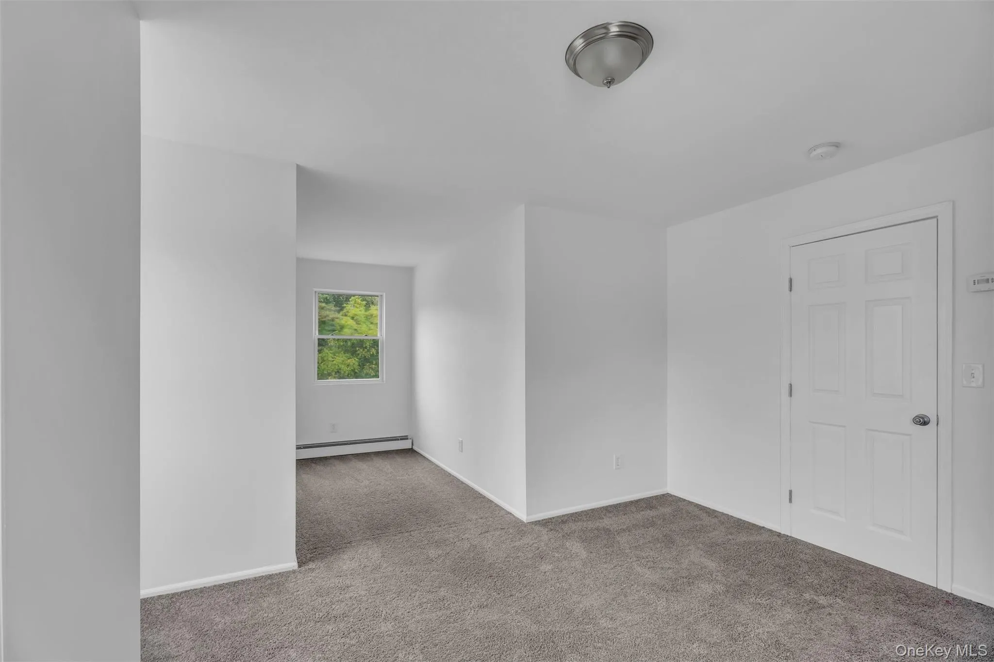 Spare room with carpet flooring and a baseboard radiator Spare room with carpet flooring and a baseboard radiator