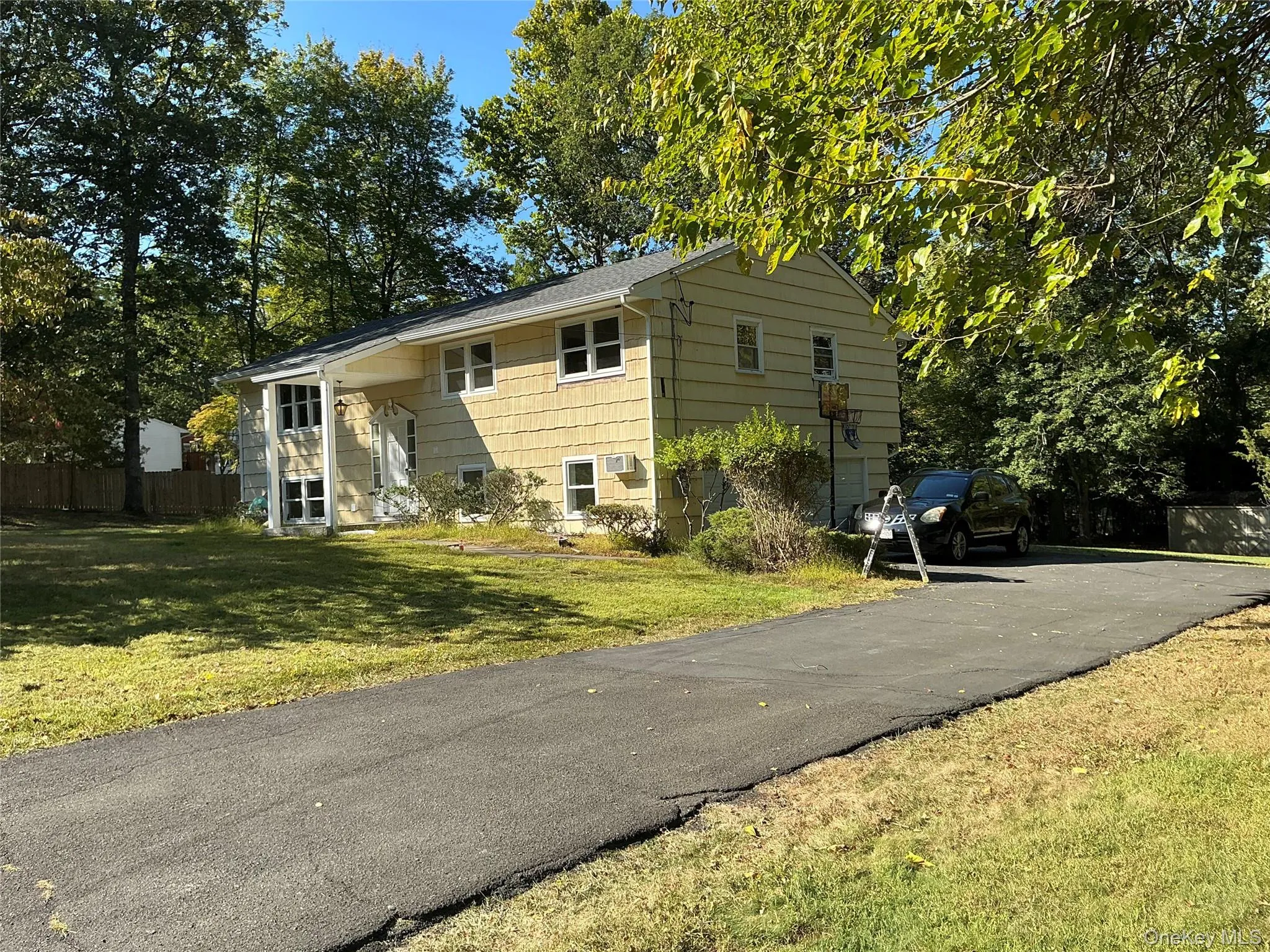 Bi-level home with a front yard and driveway Bi-level home with a front yard and driveway