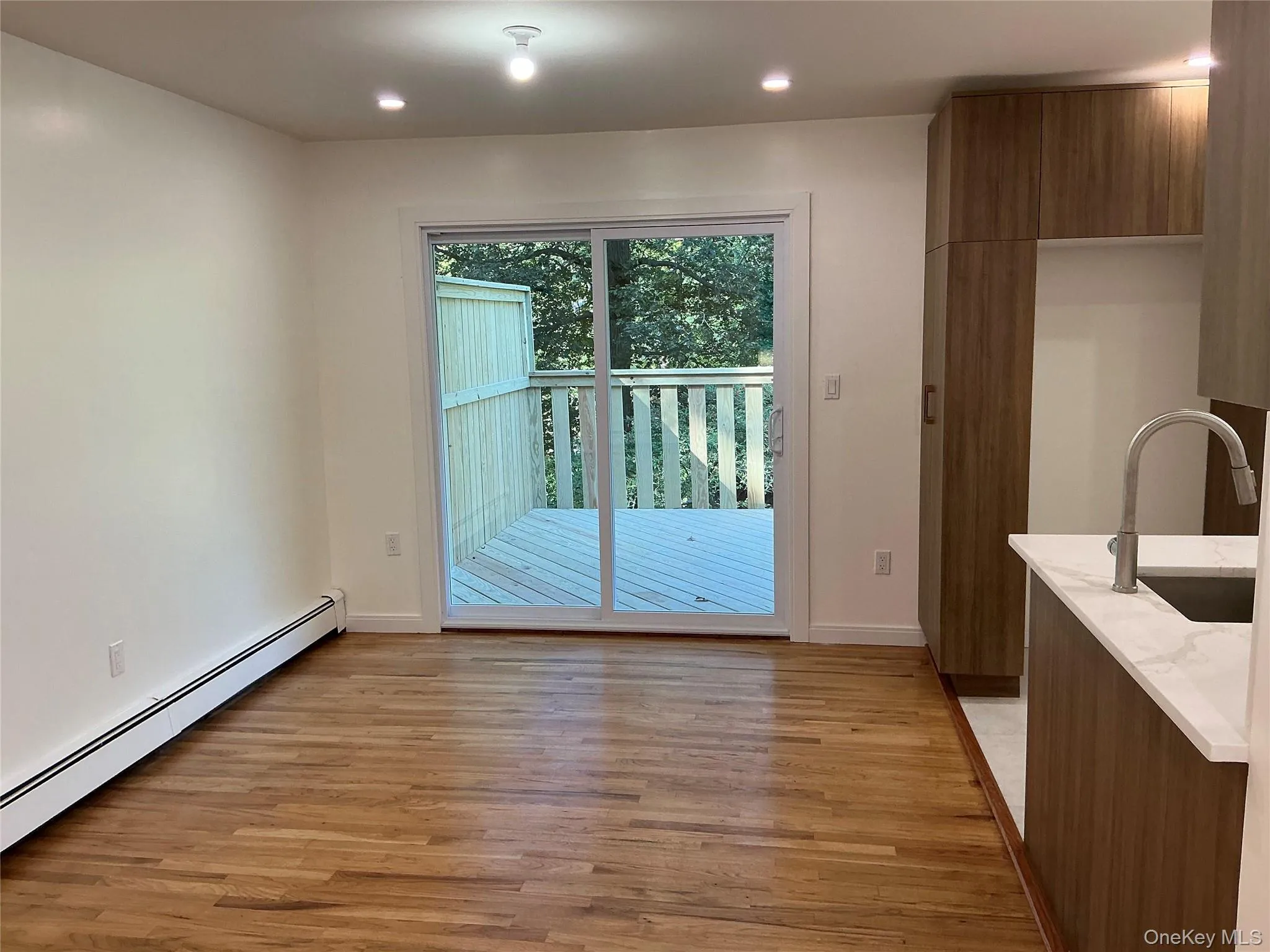 Unfurnished dining area with light wood-type flooring, a baseboard radiator, and recessed lighting Unfurnished dining area with light wood-type flooring, a baseboard radiator, and recessed lighting