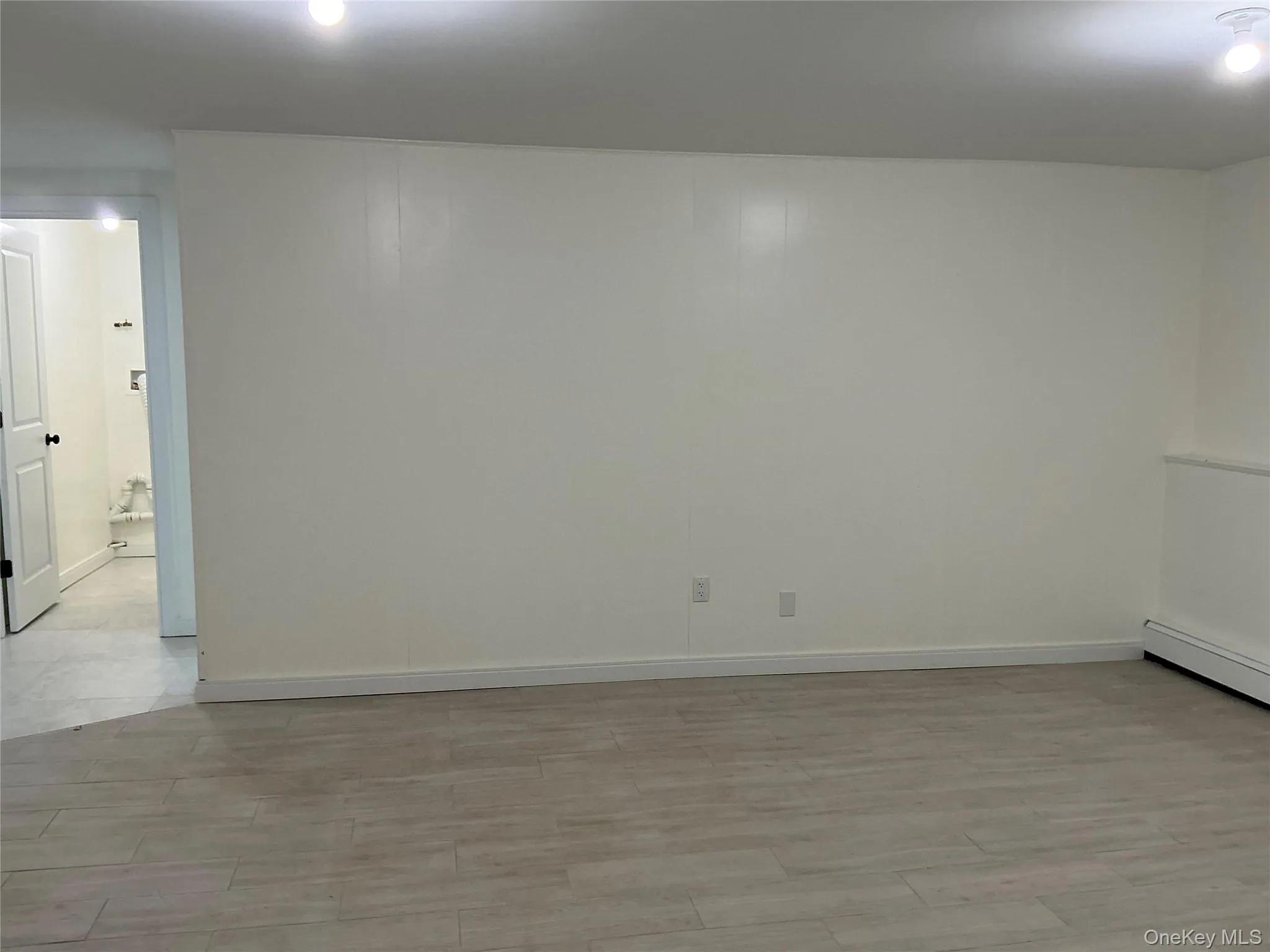Empty room featuring light wood-type flooring and baseboards Empty room featuring light wood-type flooring and baseboards