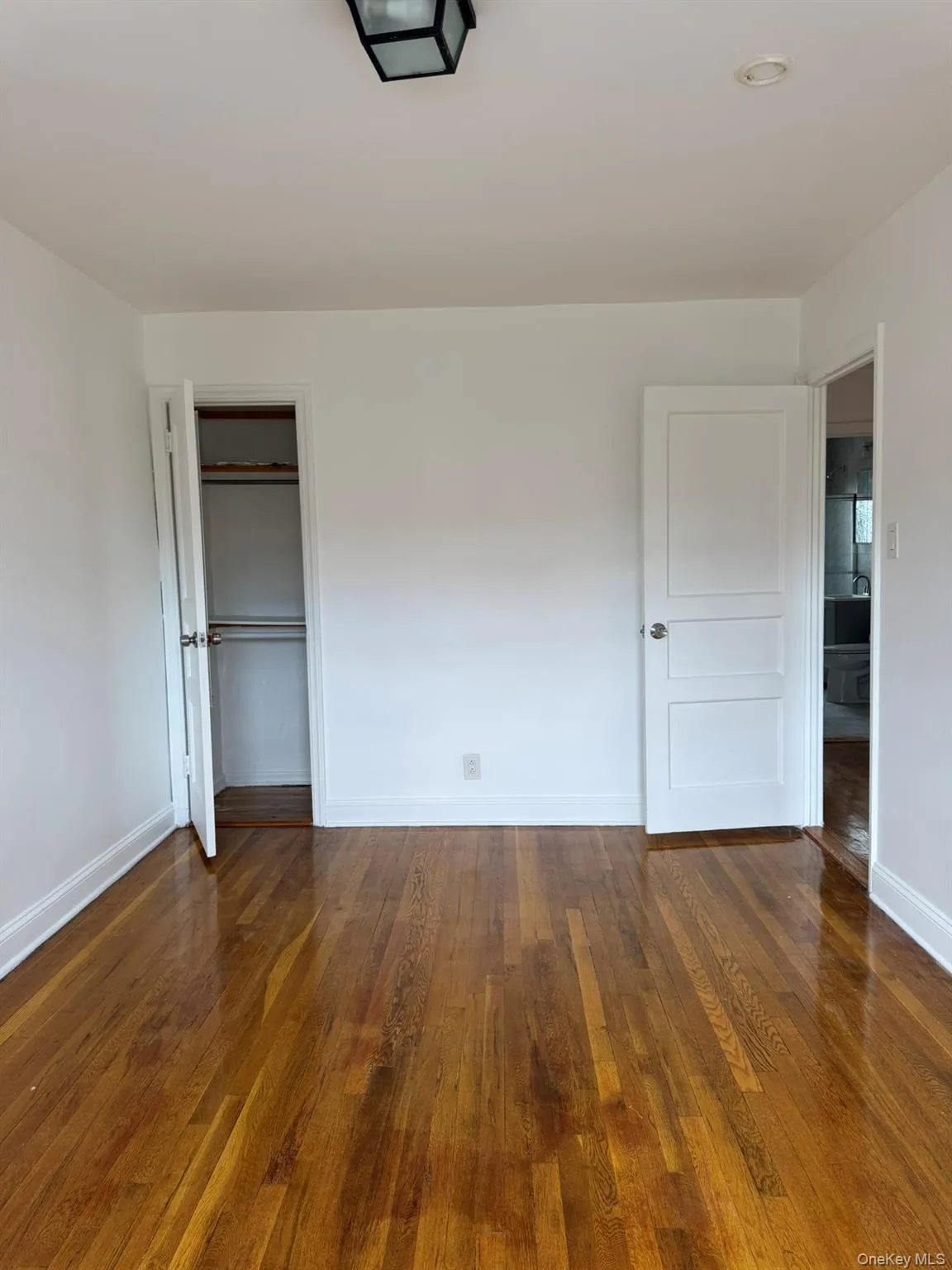 Unfurnished bedroom with dark wood-style flooring and a closet Unfurnished bedroom with dark wood-style flooring and a closet