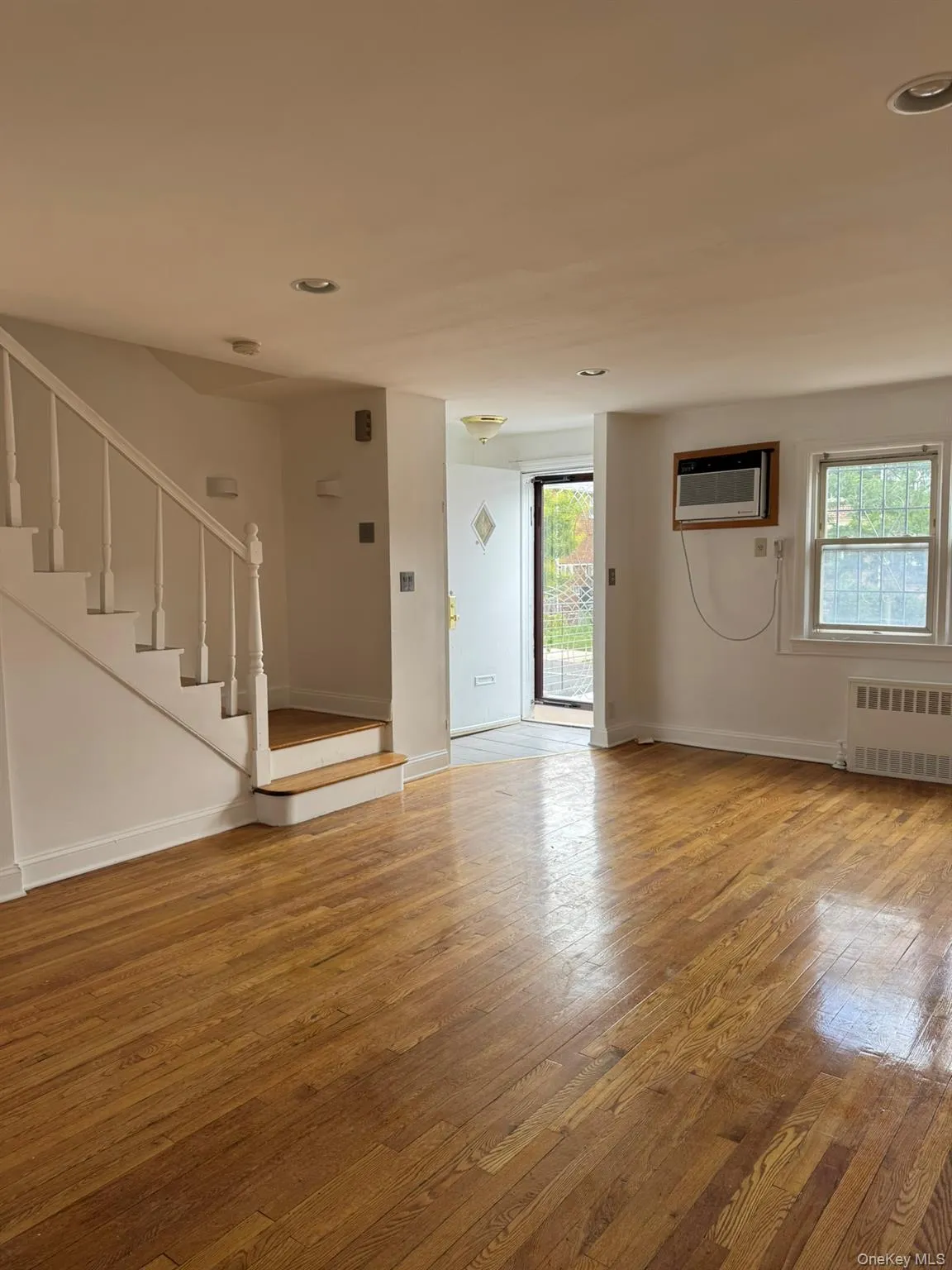 Foyer with light wood-style flooring, stairs, radiator heating unit, and recessed lighting Foyer with light wood-style flooring, stairs, radiator heating unit, and recessed lighting