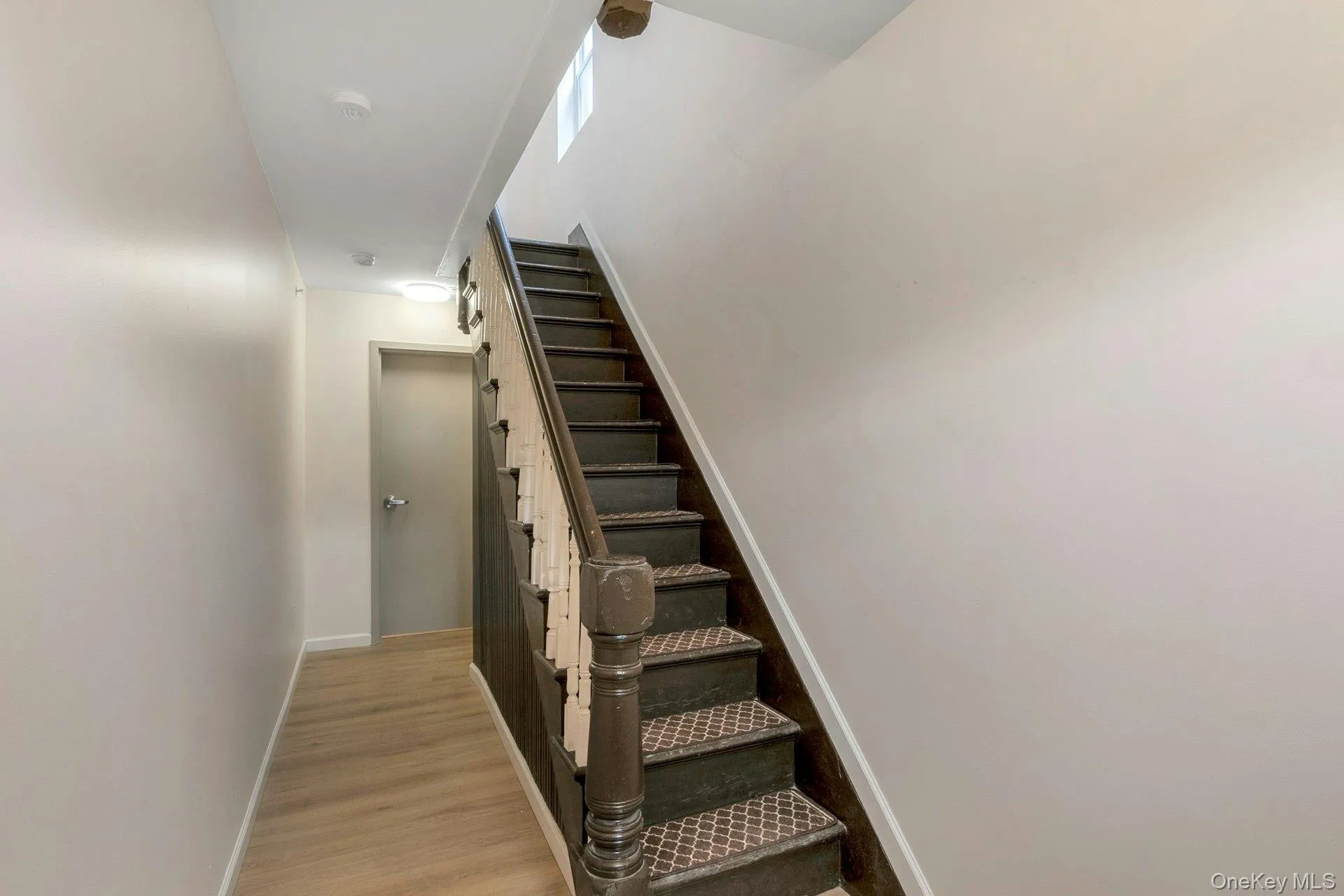 Staircase with baseboards and wood finished floors Staircase with baseboards and wood finished floors