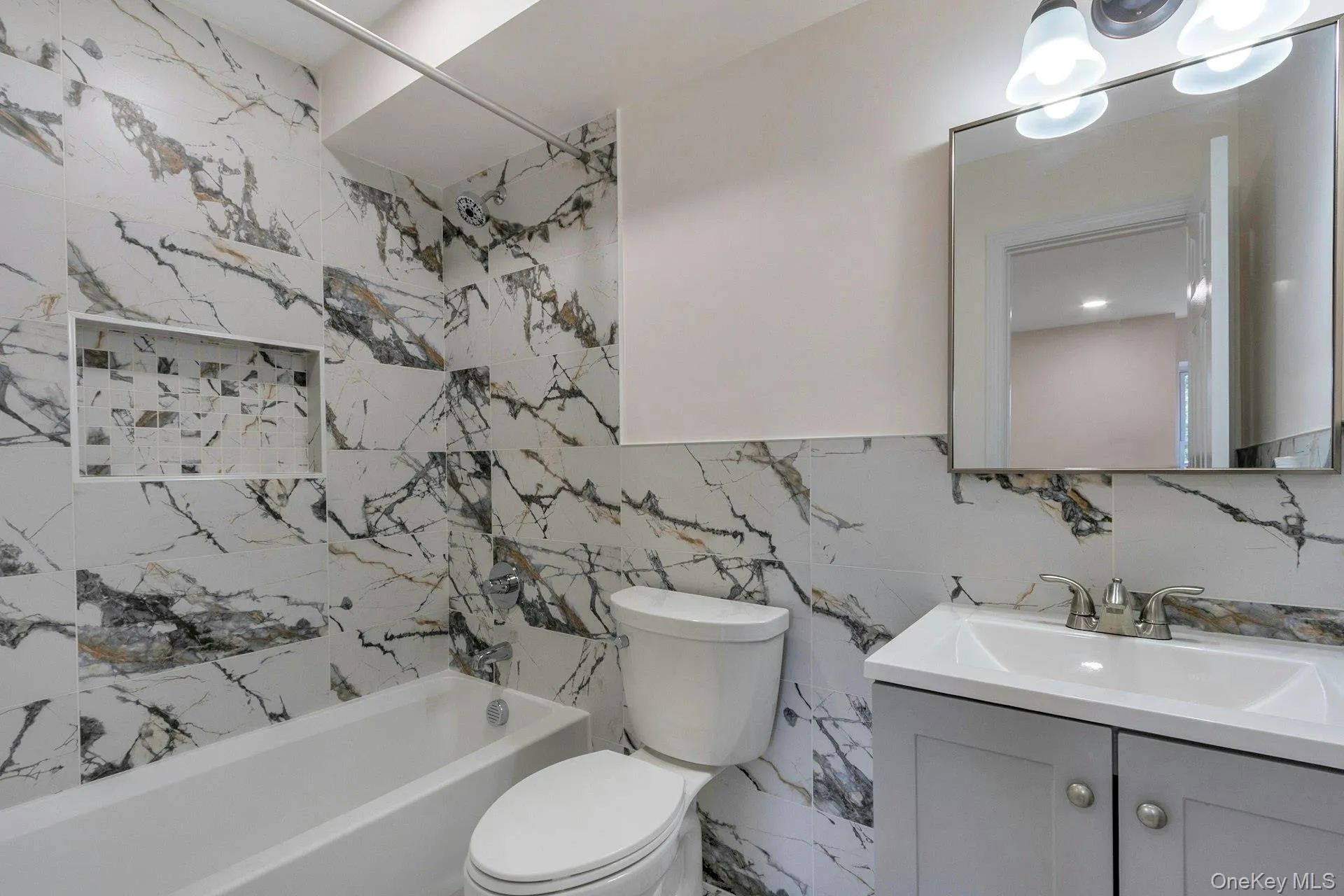 Full bathroom with shower / bathtub combination, vanity, and tile walls Full bathroom with shower / bathtub combination, vanity, and tile walls