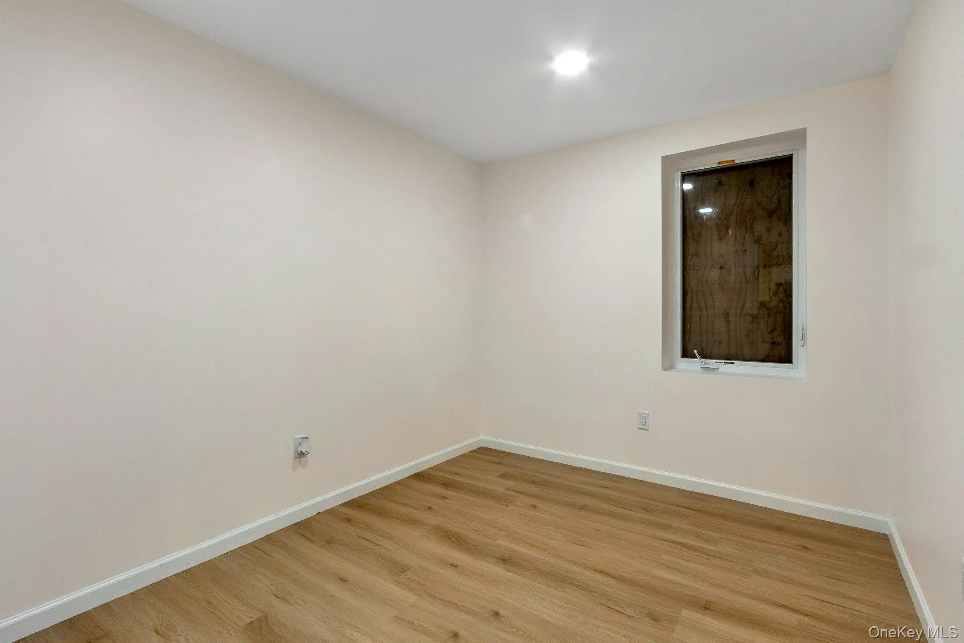 Empty room with baseboards and light wood-type flooring Empty room with baseboards and light wood-type flooring