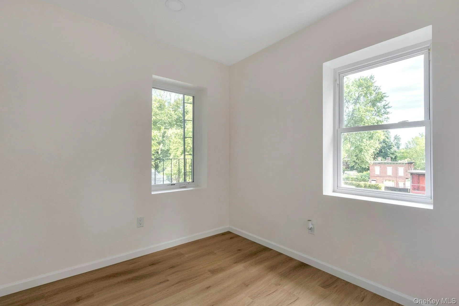 Spare room with baseboards and light wood-type flooring Spare room with baseboards and light wood-type flooring