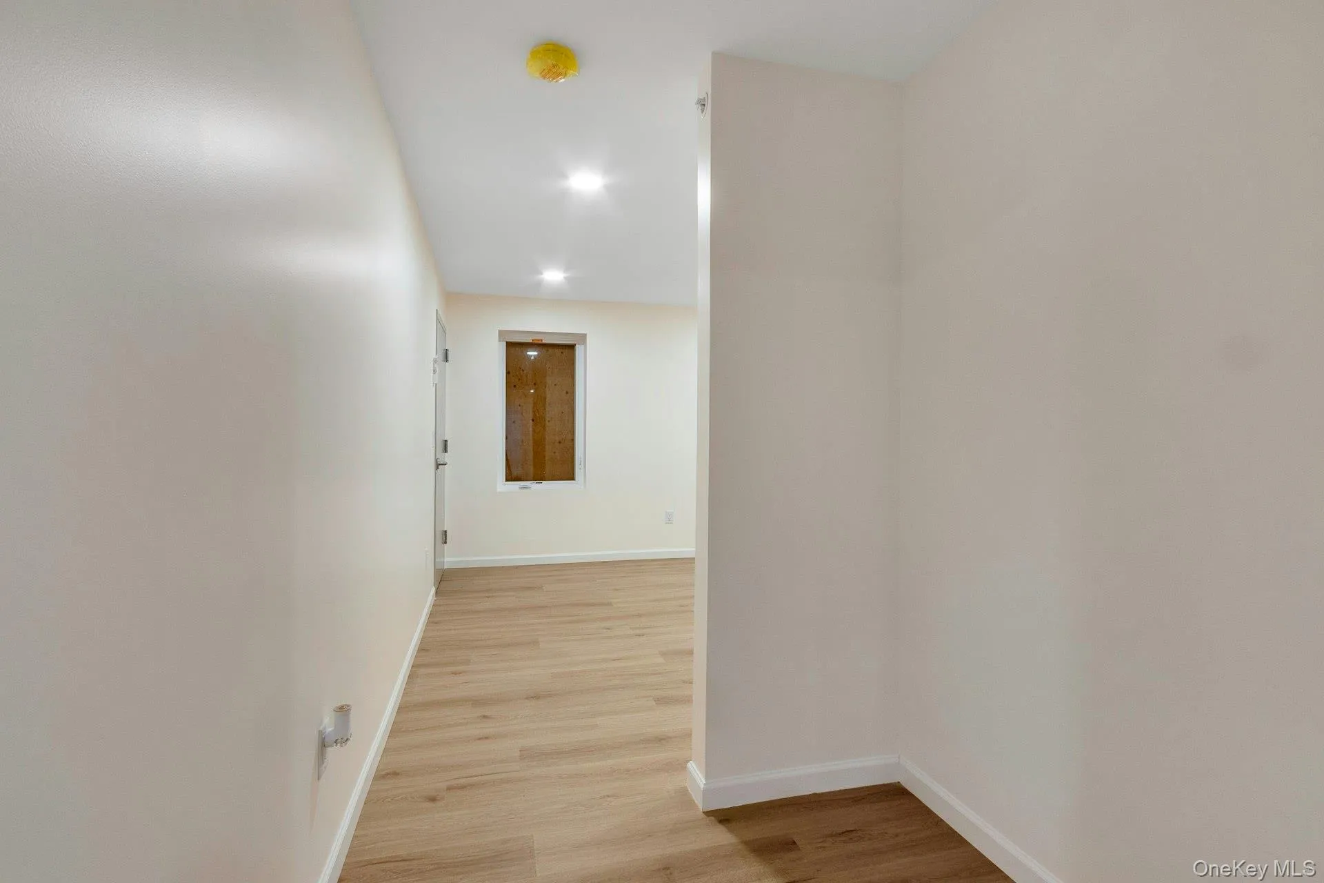 Corridor with light wood-type flooring and recessed lighting Corridor with light wood-type flooring and recessed lighting