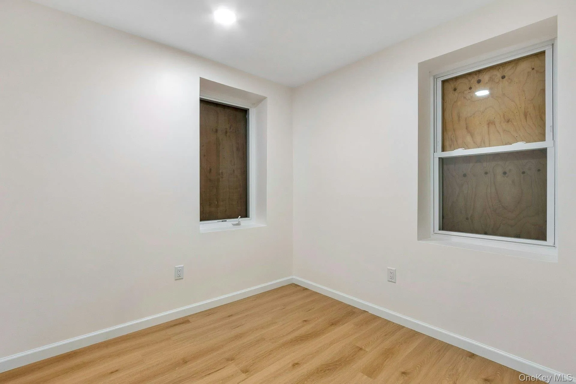 Spare room featuring wood finished floors and baseboards Spare room featuring wood finished floors and baseboards